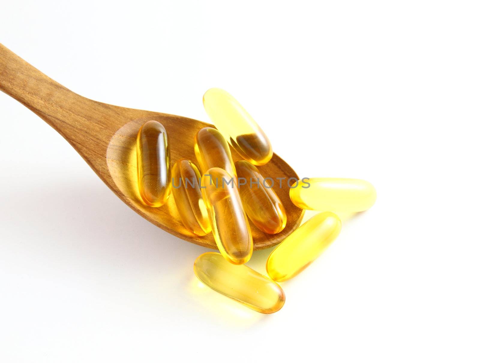 vitamins in wooden spoon on white background  by nuchylee