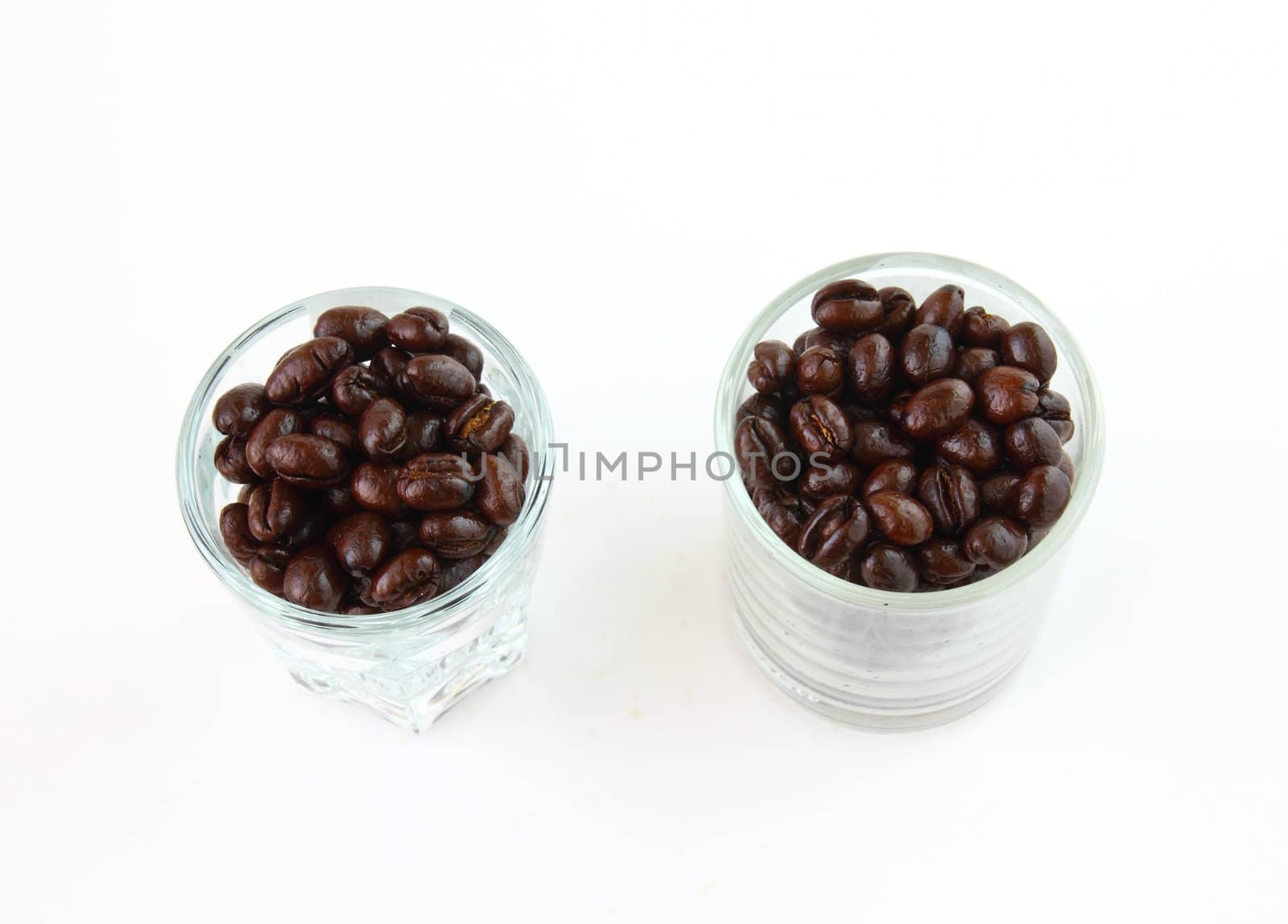Coffee beans in glasses on white background