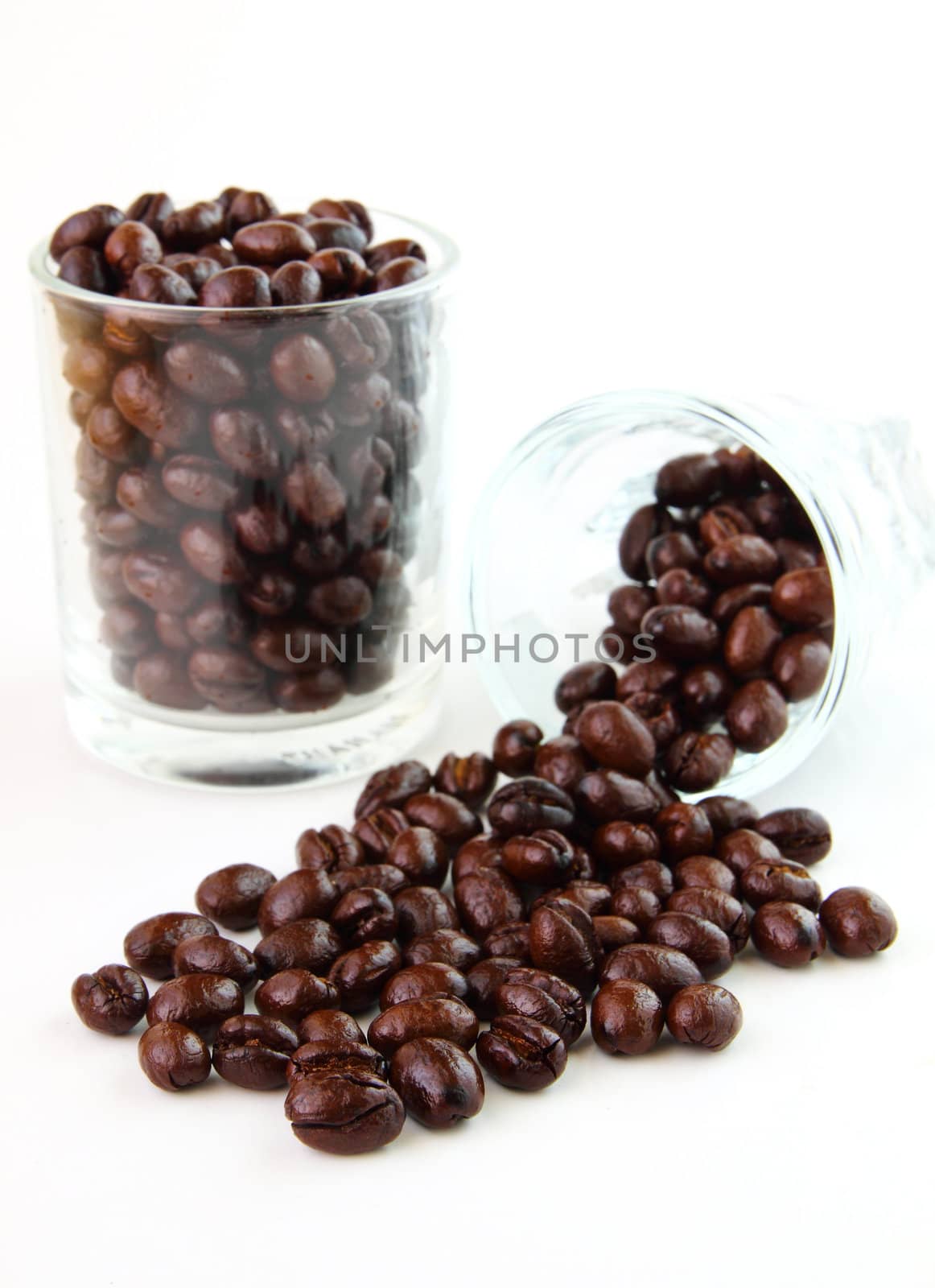 Coffee beans in glasses on white background