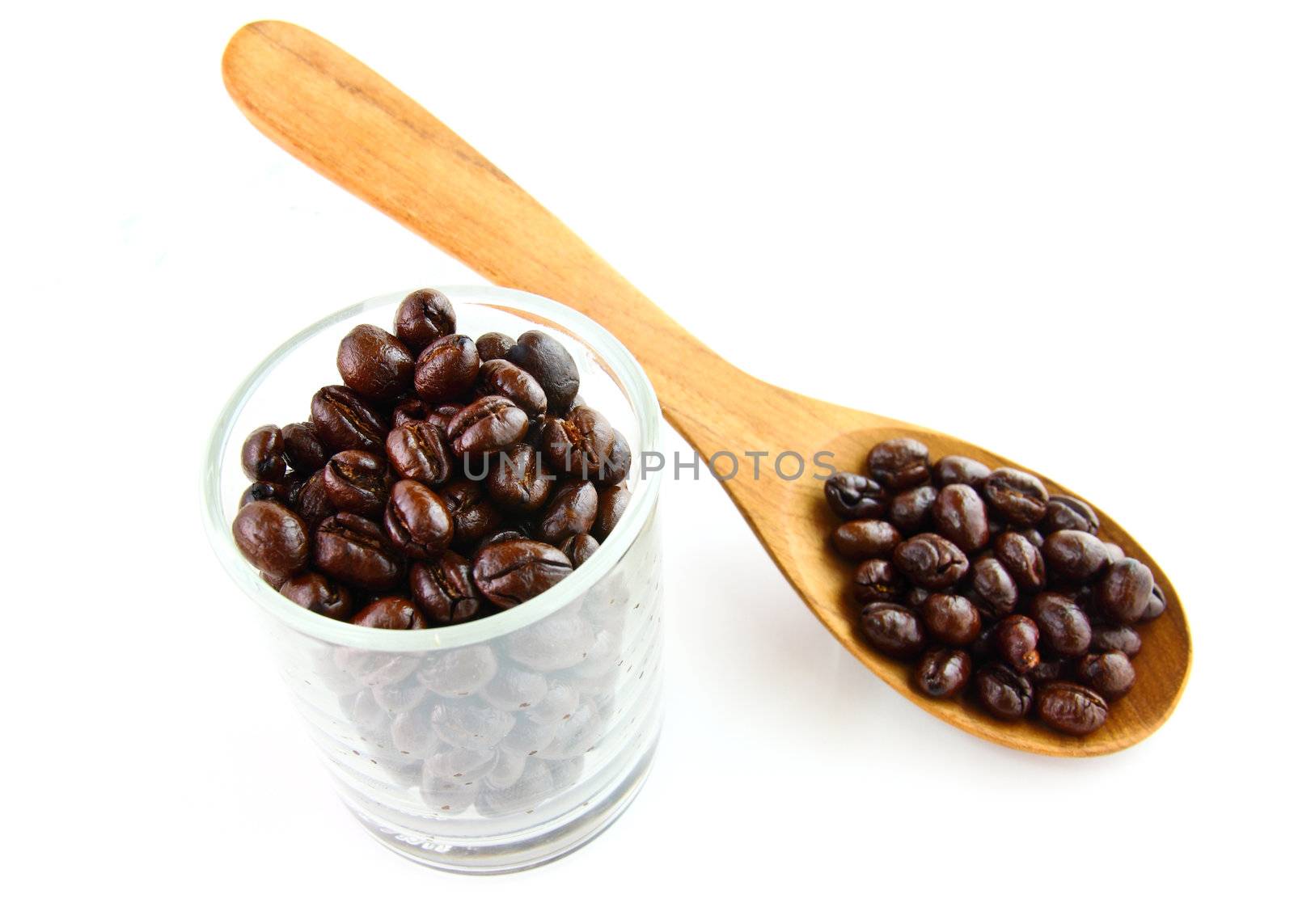 Coffee beans in a glass with wooden spoon on white background  by nuchylee