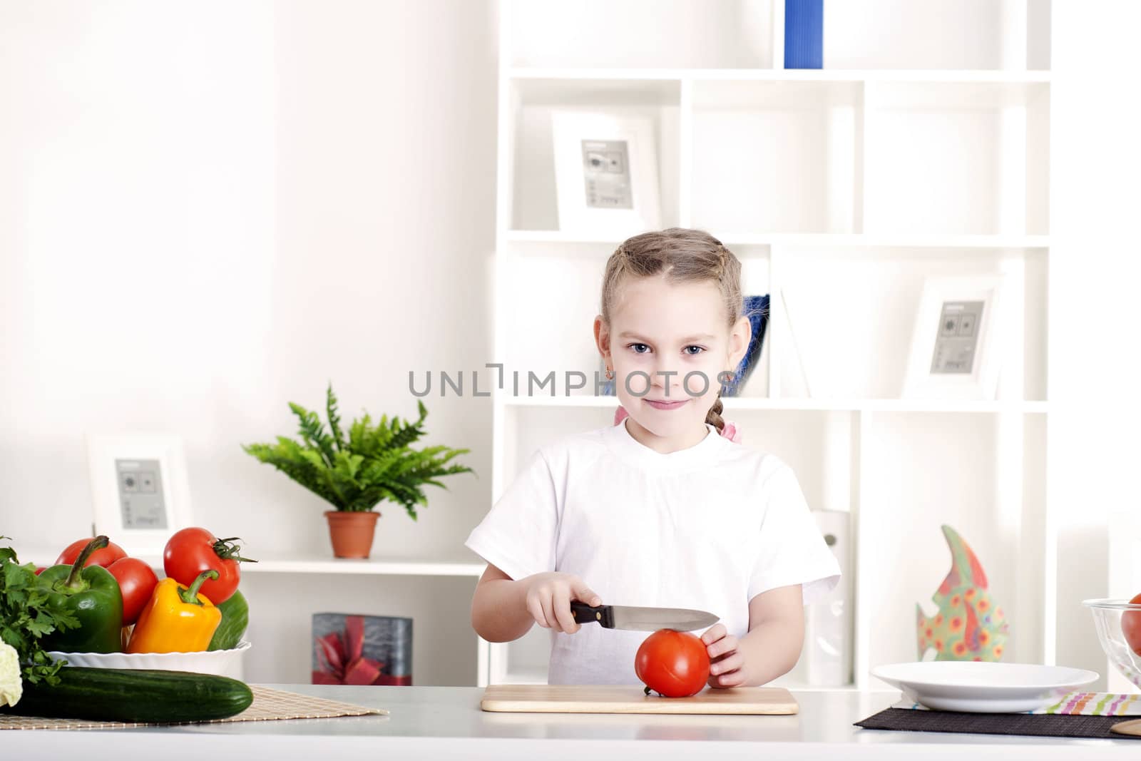 beautiful girl in the kitchen cooking vegetables