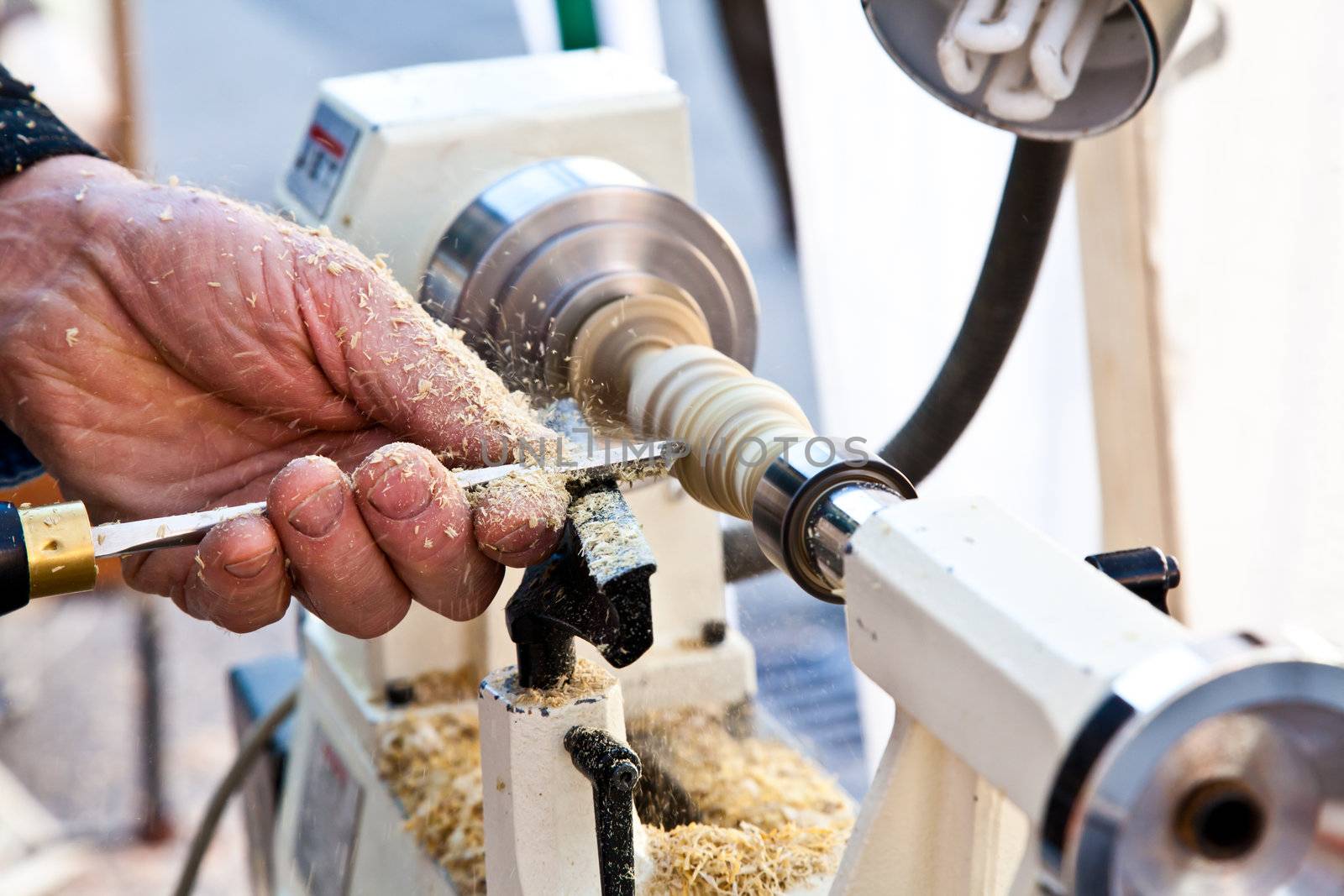 Old worker hands at lathe