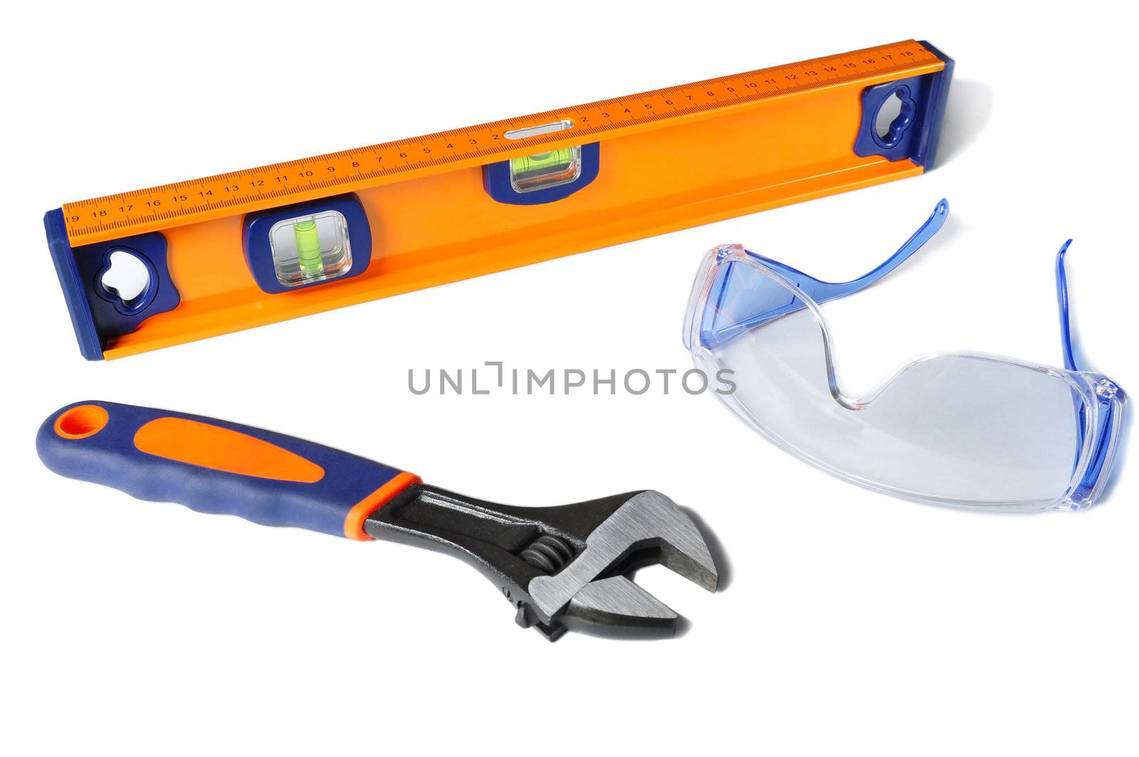 Safety glasses, a wrench and a ruller isolated on a white background