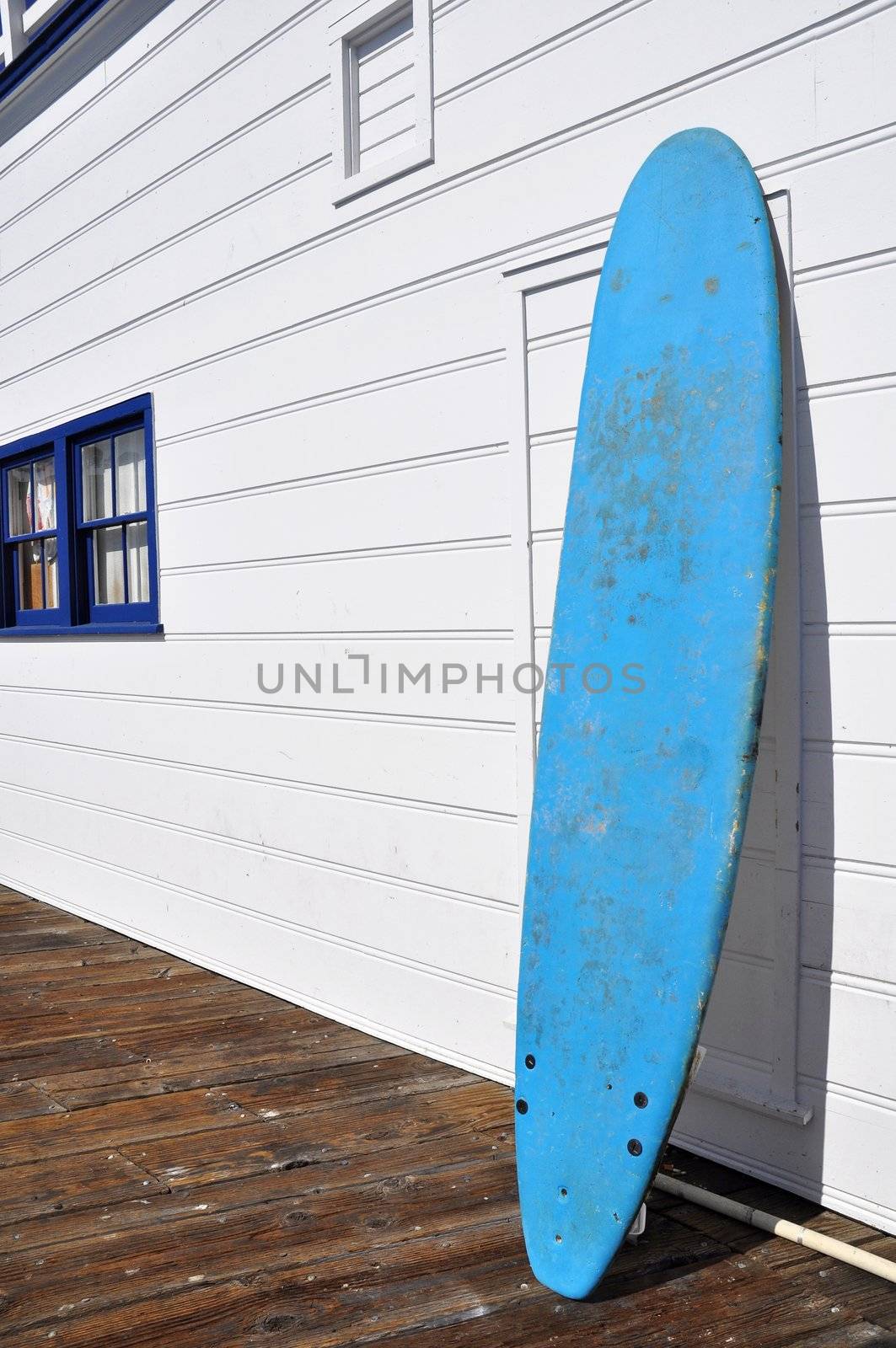 A blue surf board against a white wall