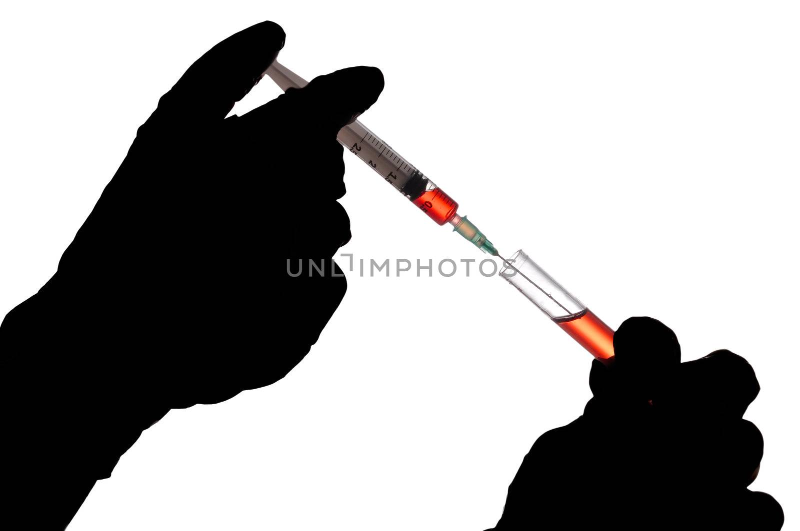 Hand holding a syringe and taking a blood sample from a tube for analysis