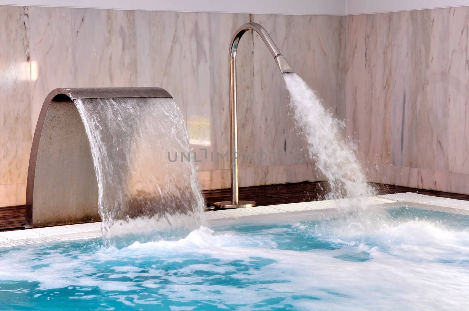 Pool with streams of water in modern spa