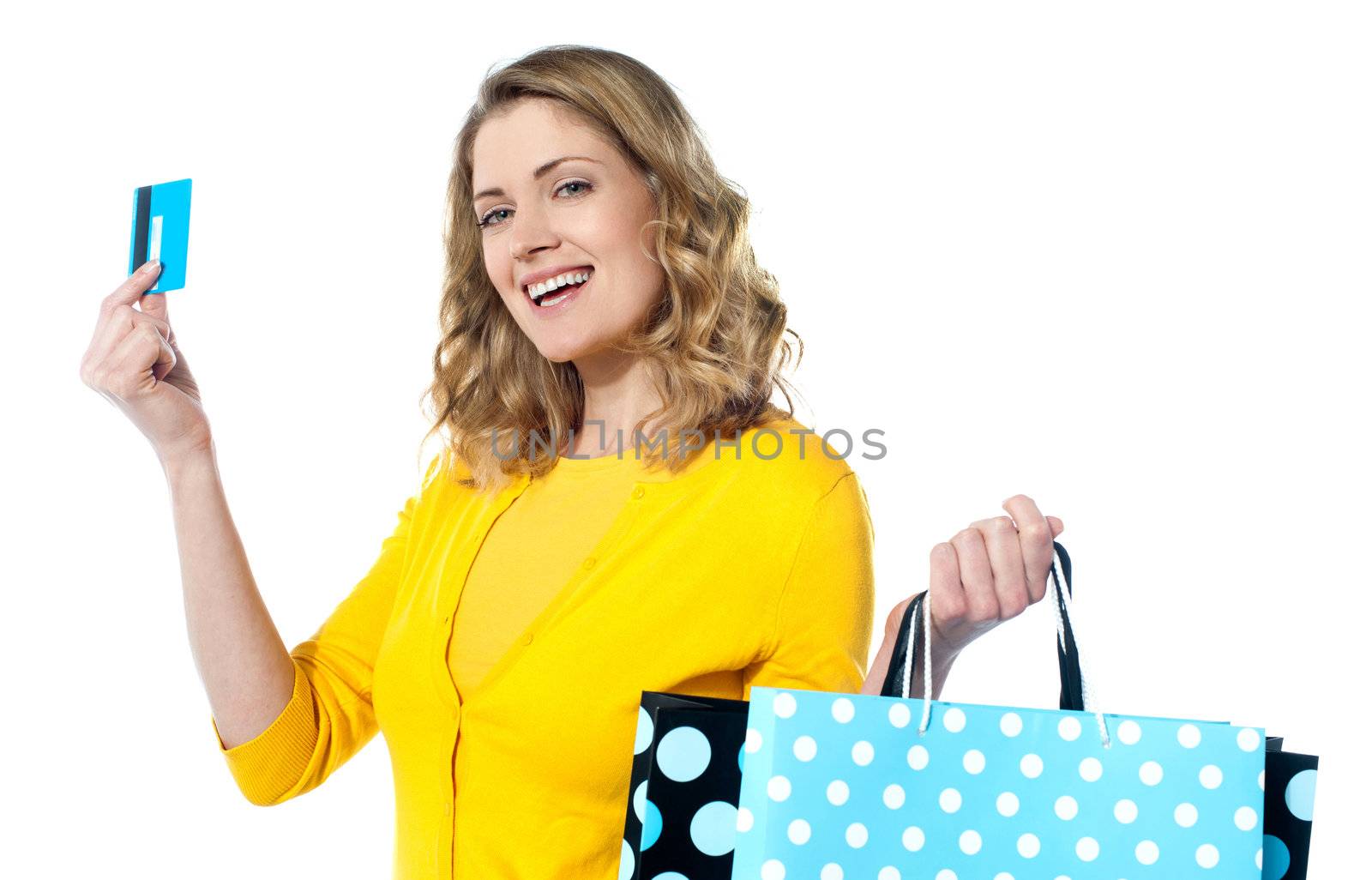 Attractive woman holding cerdit-card with shopping bags smiling against white background