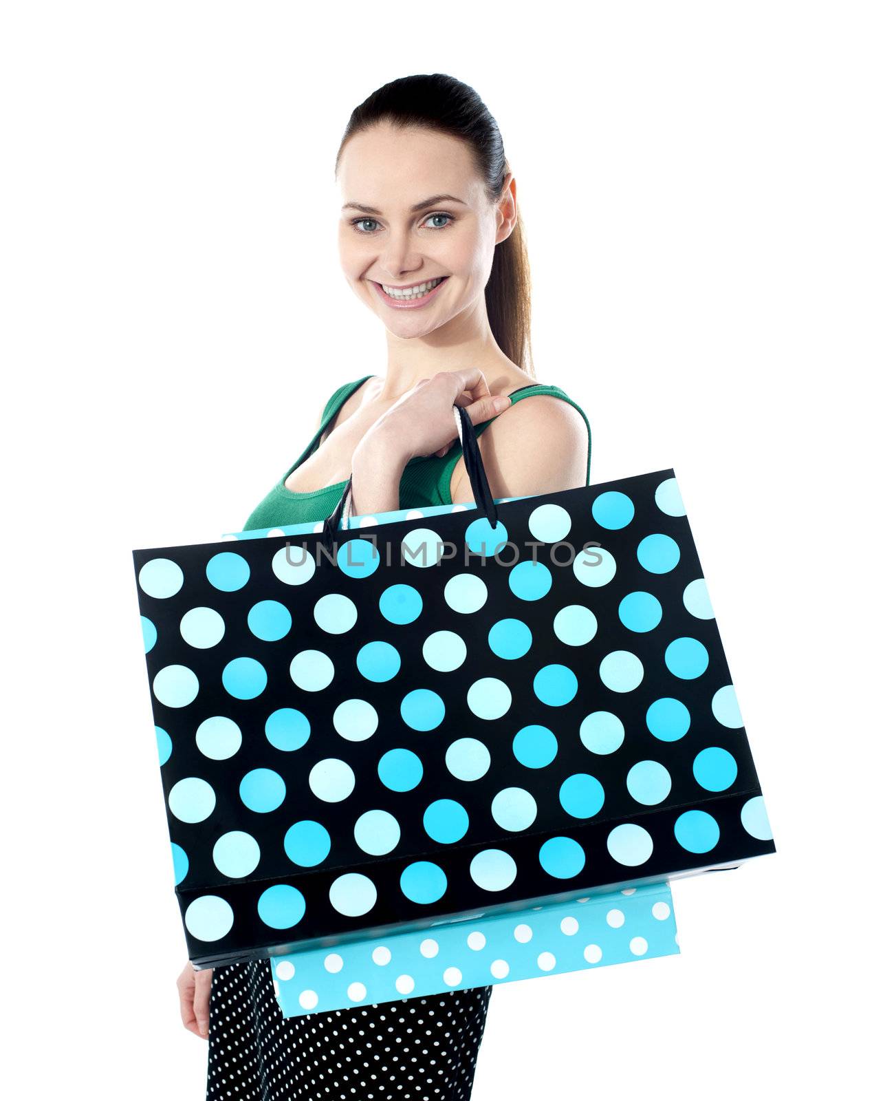 Glamorous smiling teenager shopping. Holding dotted bags