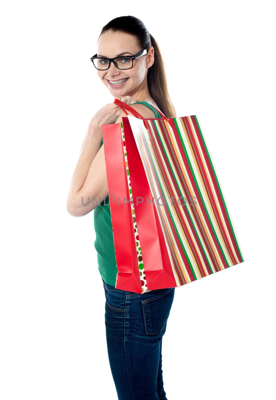 Side view of woman holding shopping bags against white background