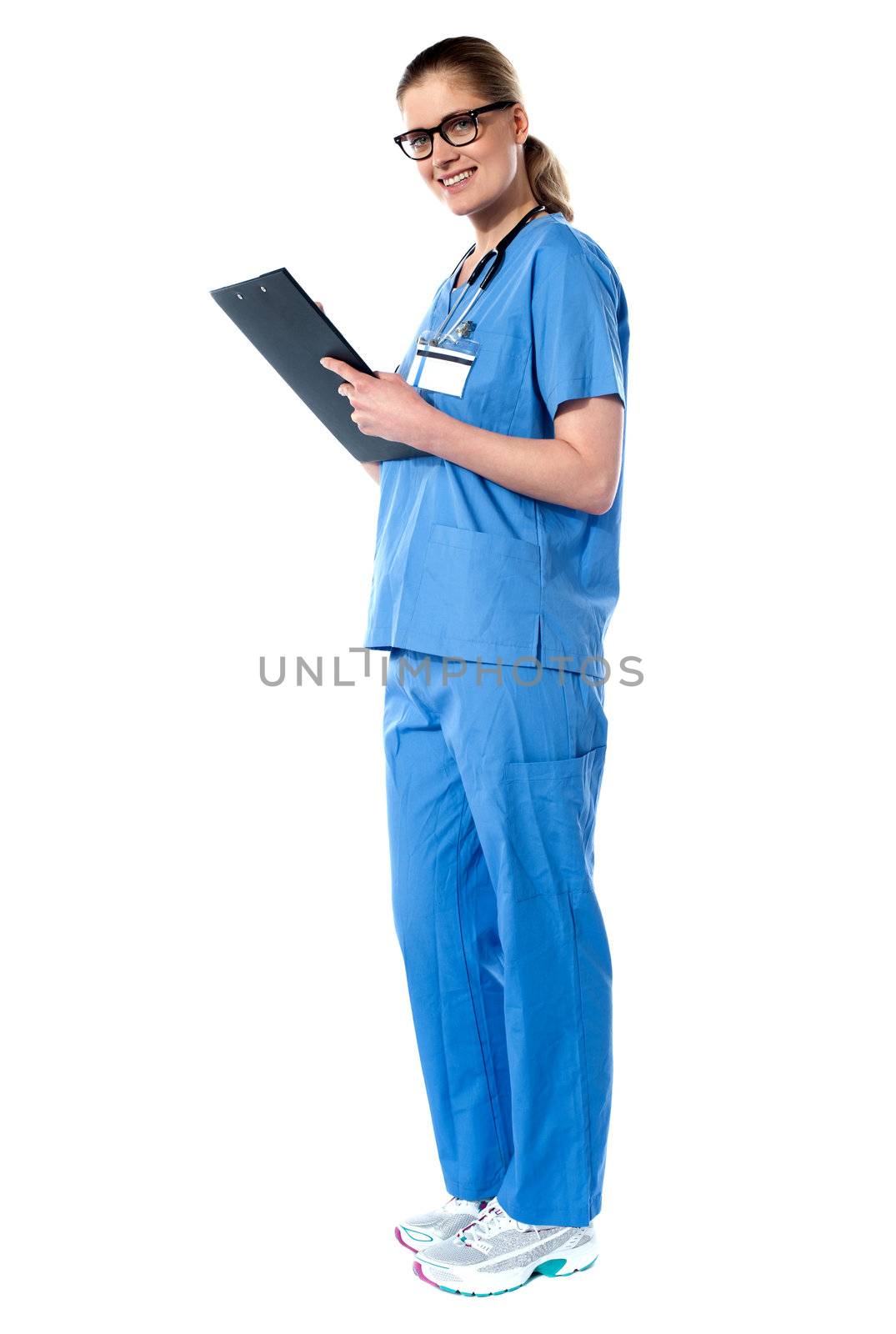 Lady doctor standing with stethoscope around her neck. Holidng clipboard