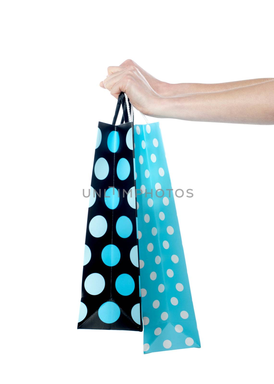 Female hand holding shopping bags isolated on white