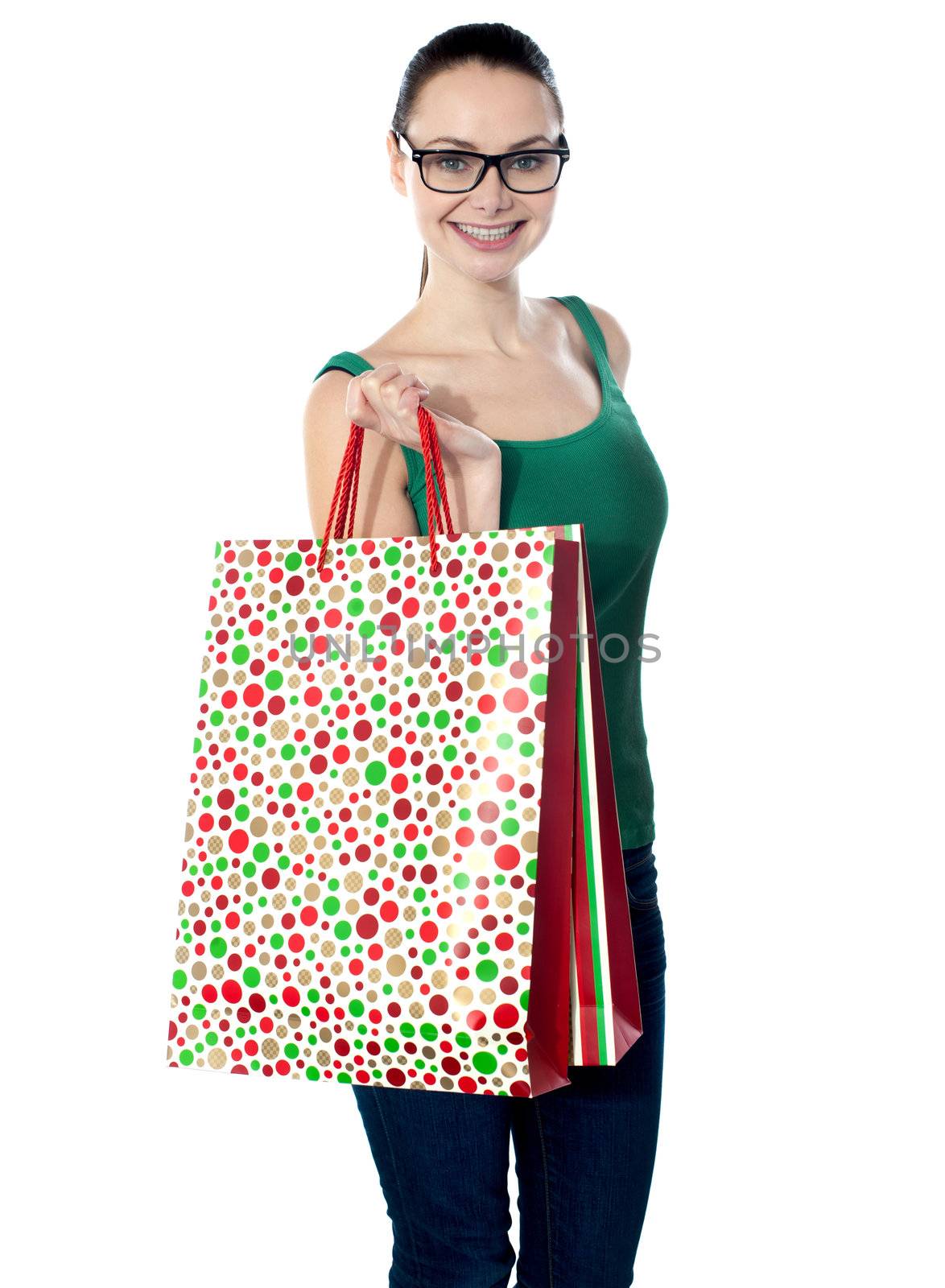 Glamorous young girl carrying shopping bags isolated over white