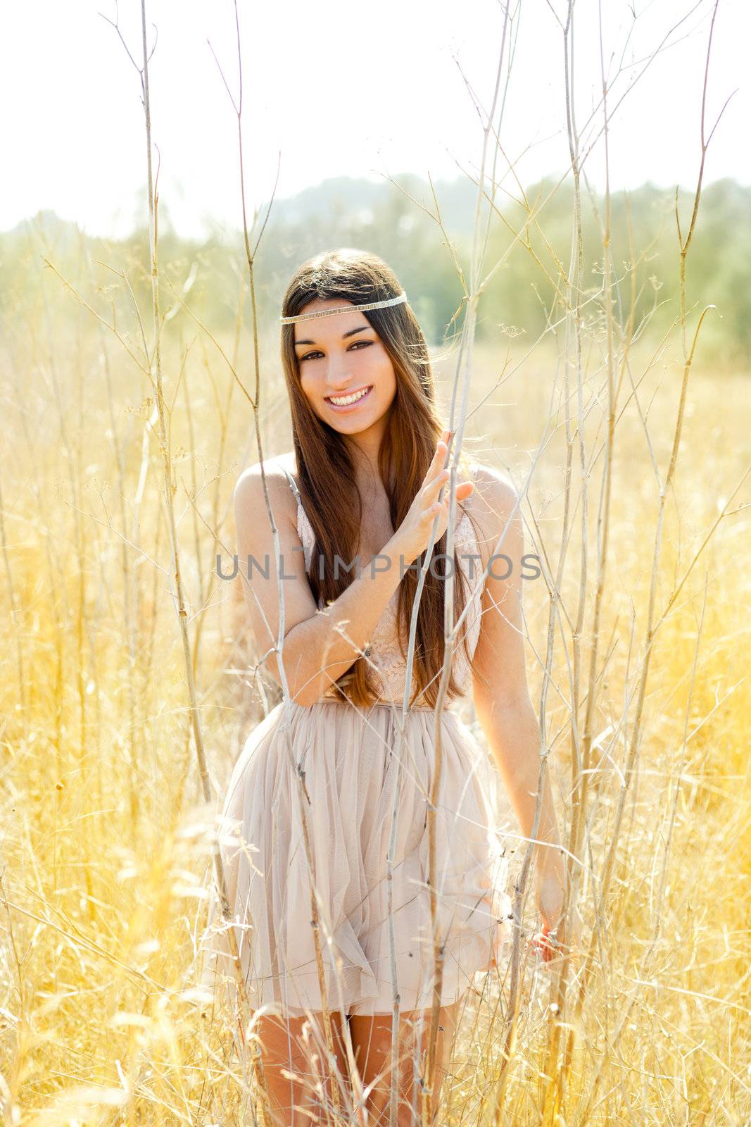 Asian indian woman walking in golden dried grass field