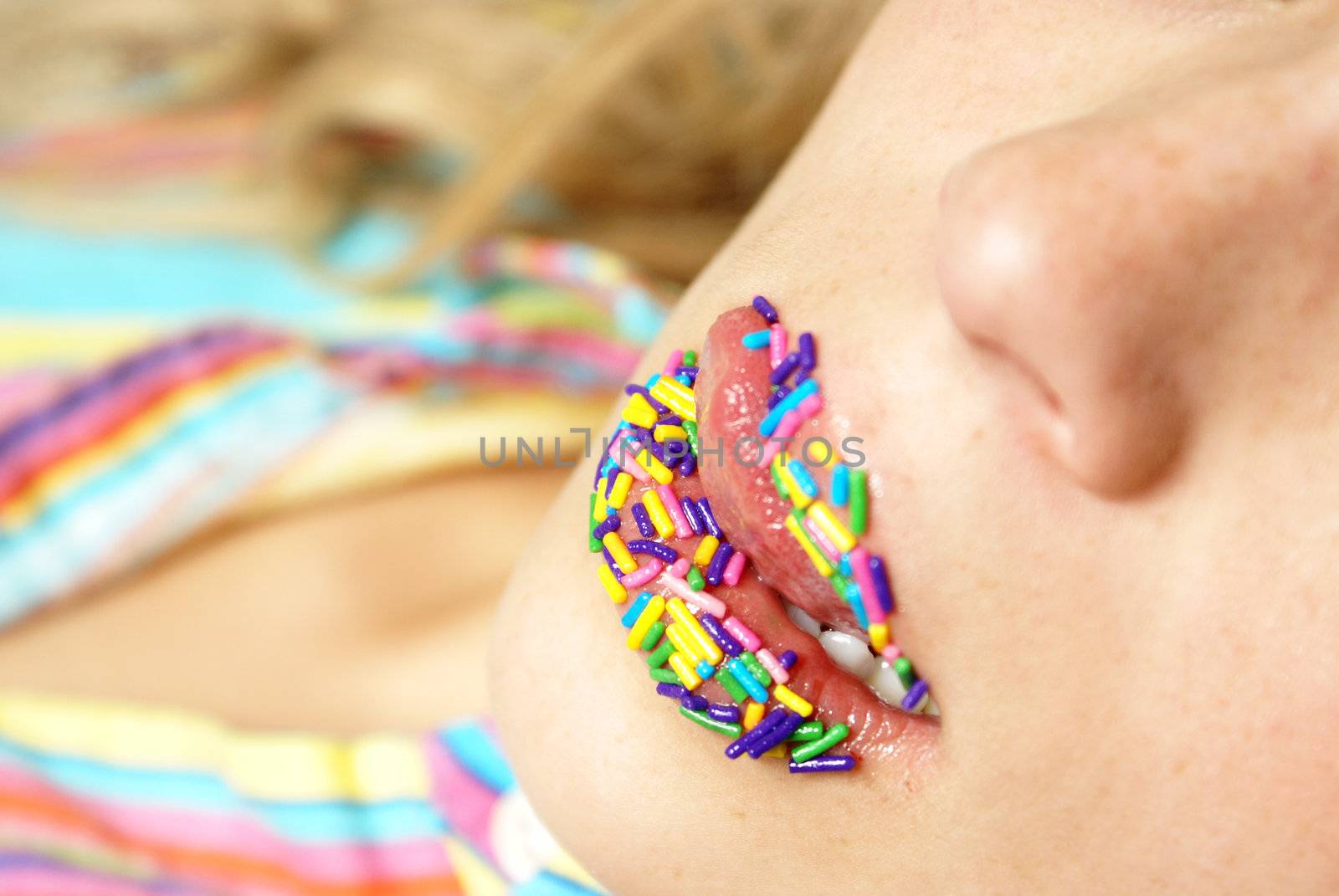 A woman licks her candy coated lips.  Shallow DOF on bottom lip.