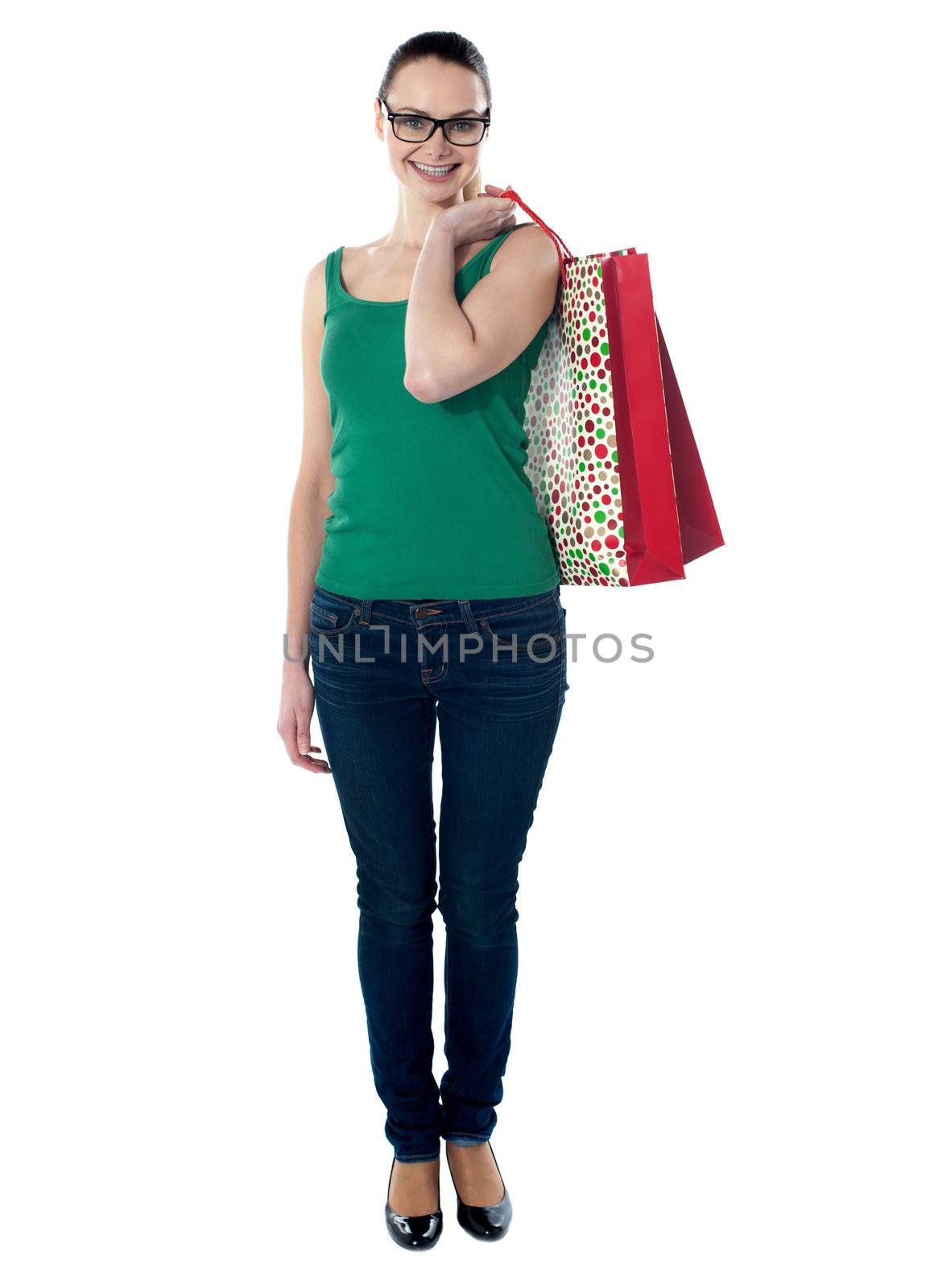 Beautiful woman holding shopping bags on her shoulders, smiling at camera