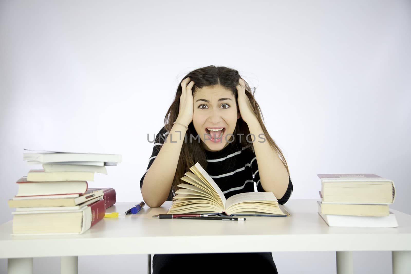 Girl studying book on a desk shouting