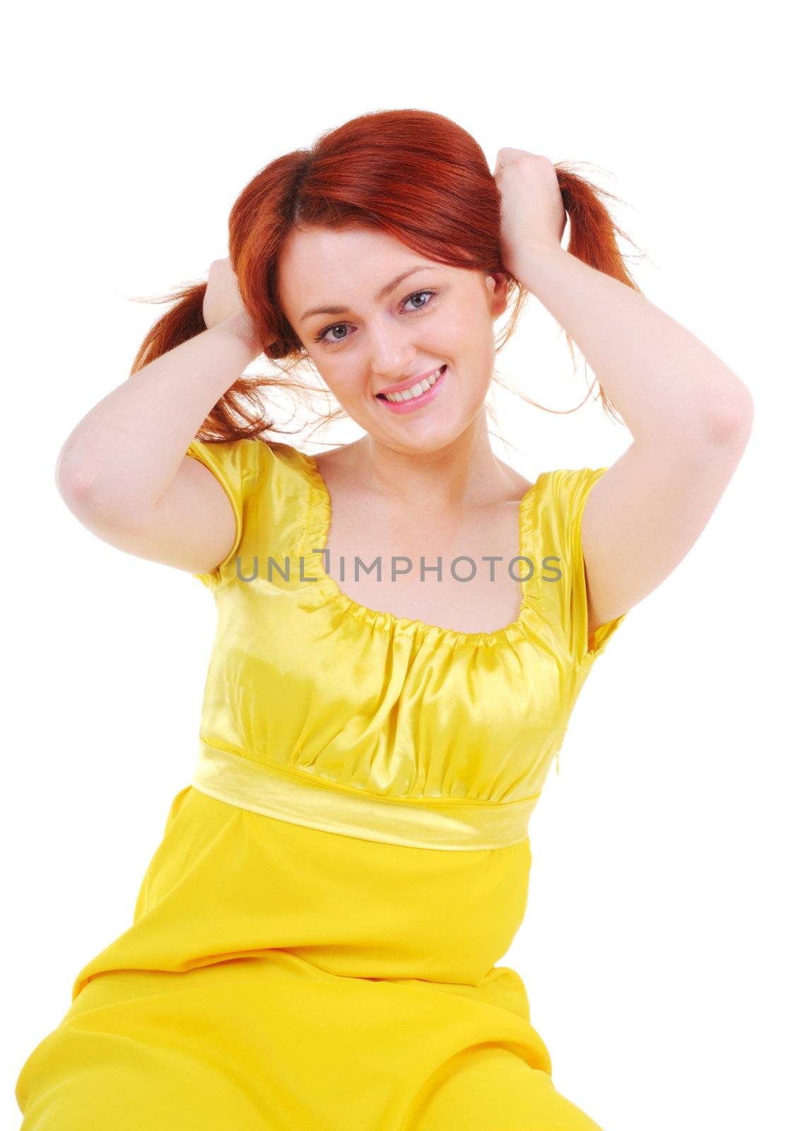 Sexual and skittish young woman in yellow dress plays with her red hair on white background