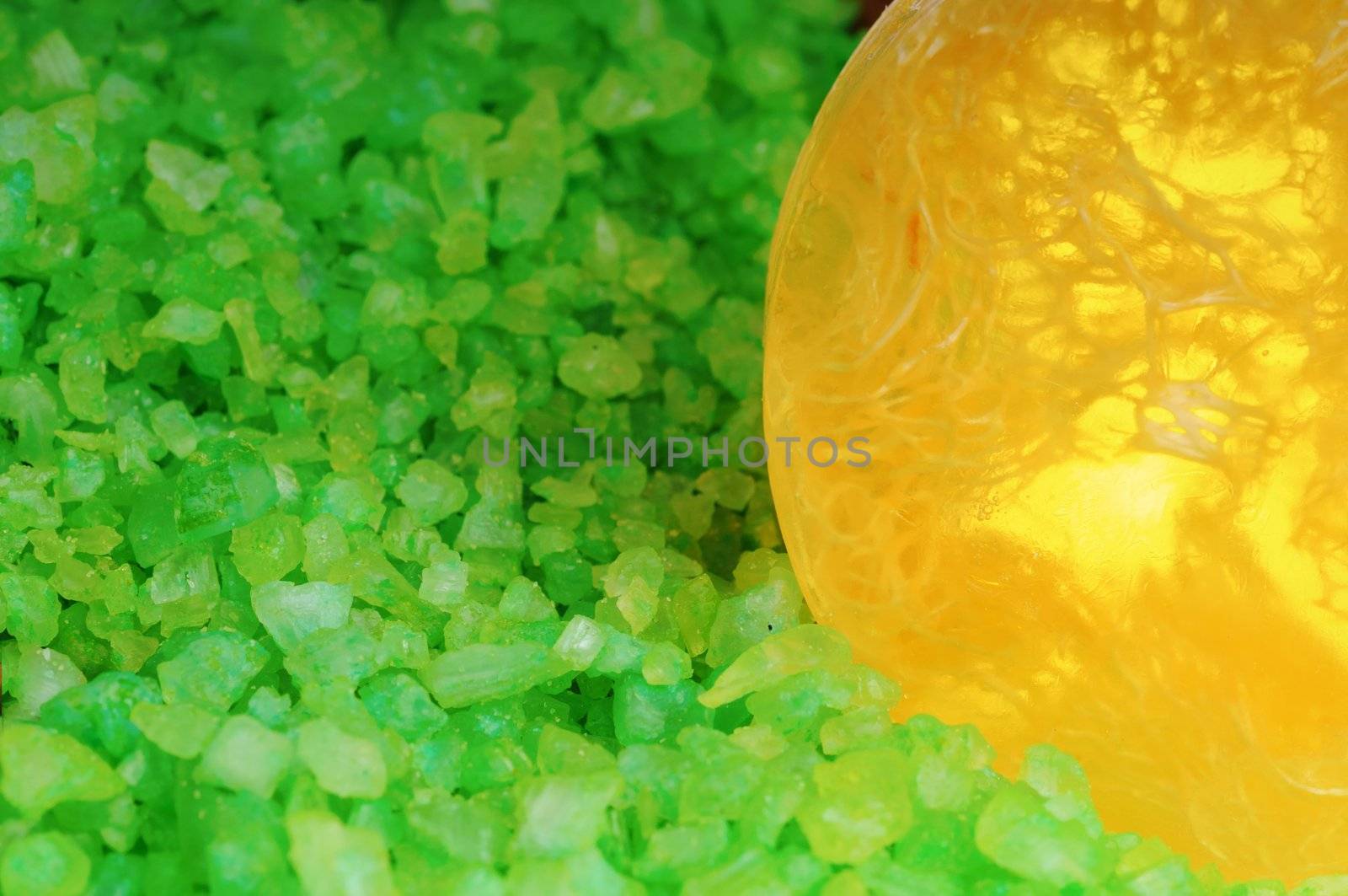 Green salt in transparent and scrubing soap. Focus on soap. Shallow DoF.