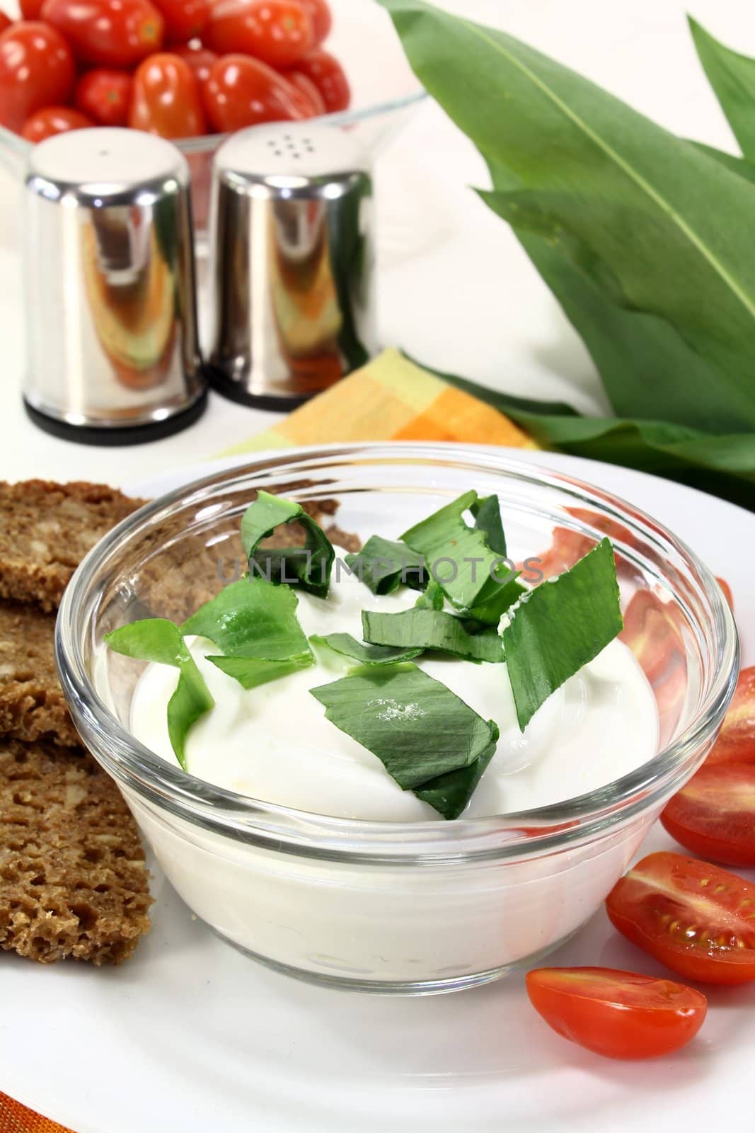 a bowl of wild garlic curd with bread and tomato