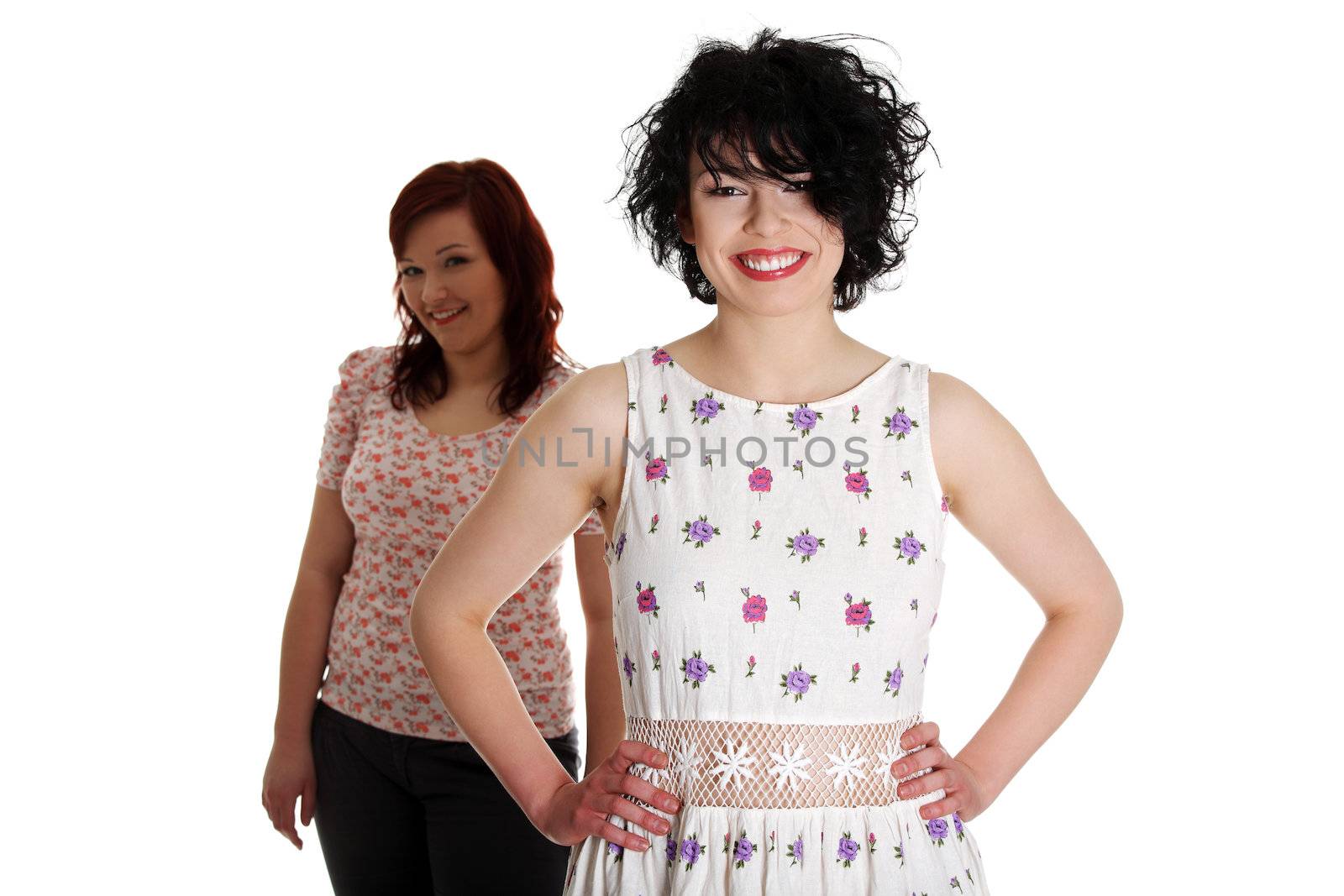 Two happy woman posing over white background.