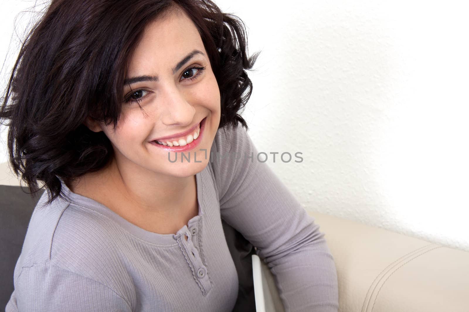 young beautiful woman is sitting an a sofa and relaxing