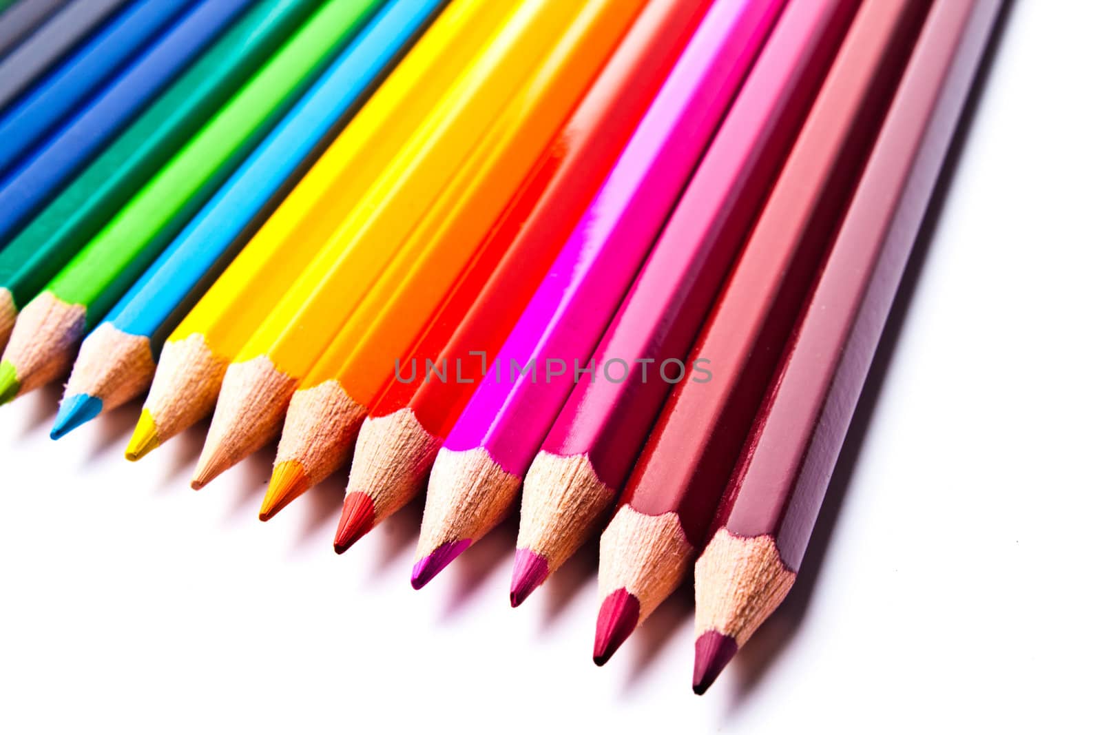 a bunch of colored pencils on a light background