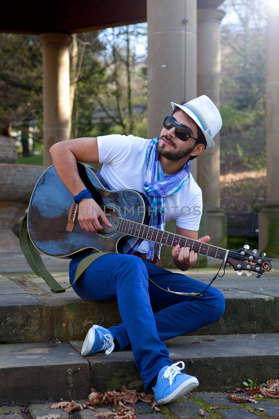 young man is playing a guitar and singing by juniart