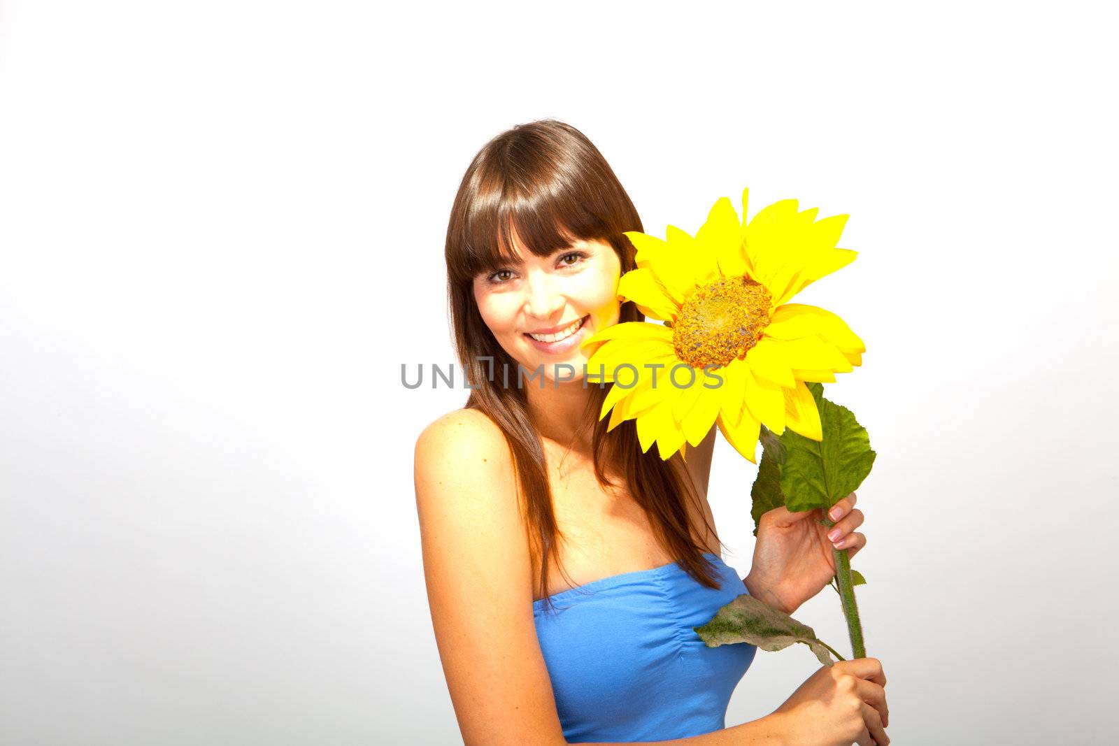 young beautiful brunette woman with a flower happy by juniart