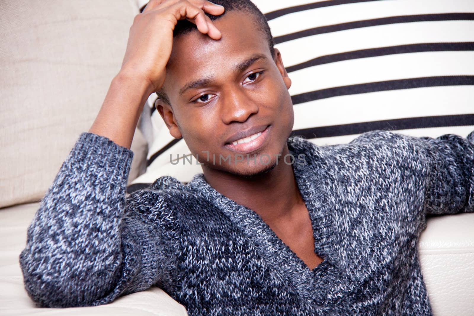 dark-skinned man sitting on the floor in front of the couch