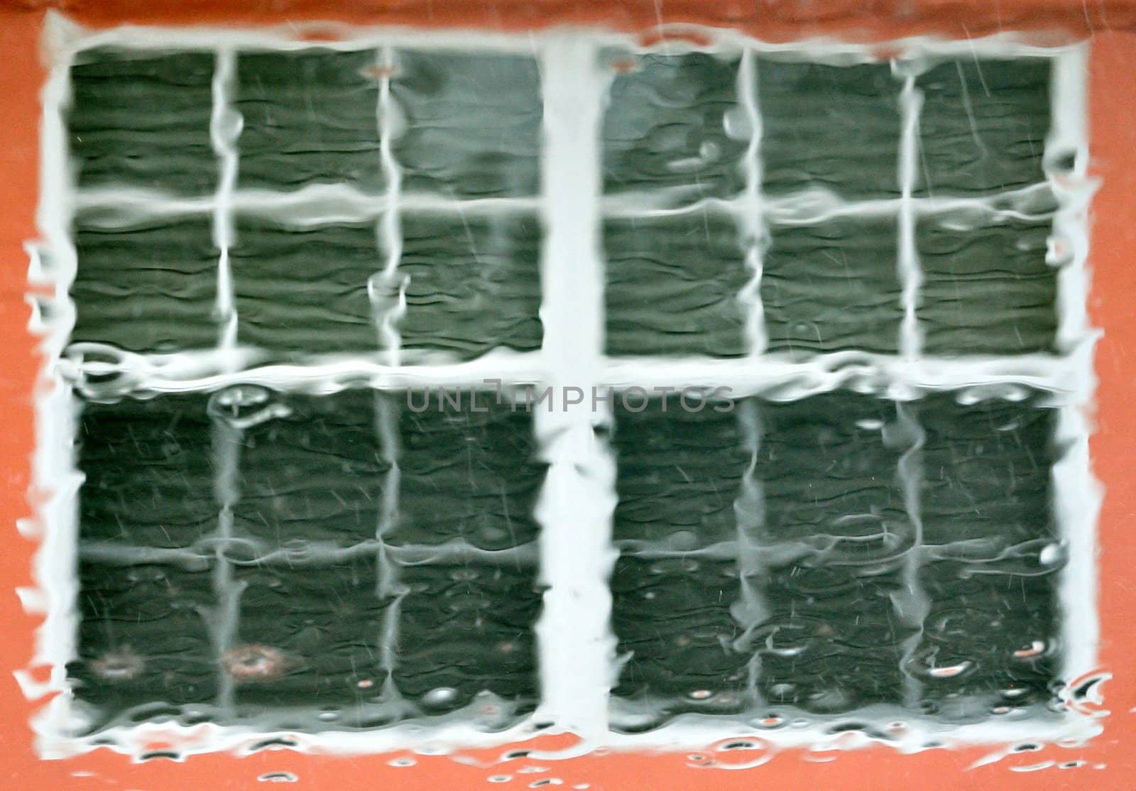 House window seen through a rainy car windshield.