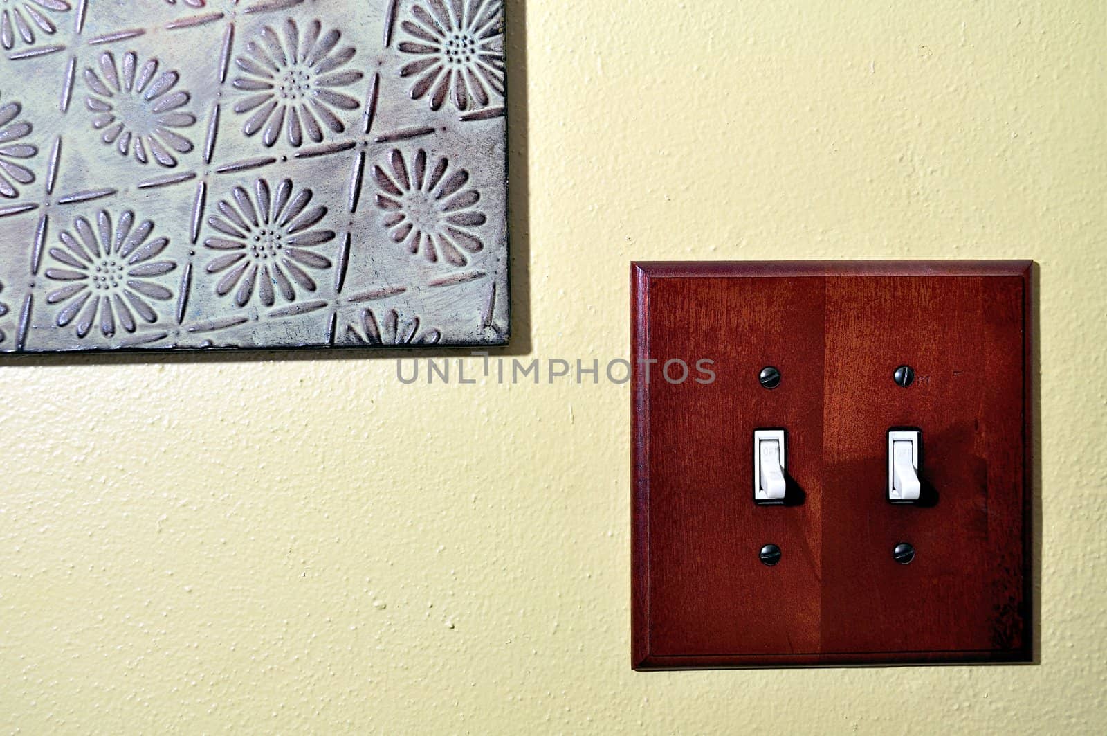 Double light switch and metal wall decoration.
