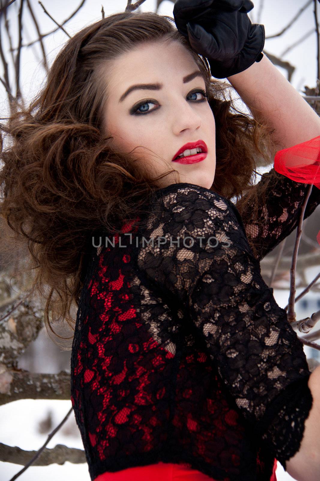 beautiful young woman outside in winter with dark hair and red lips