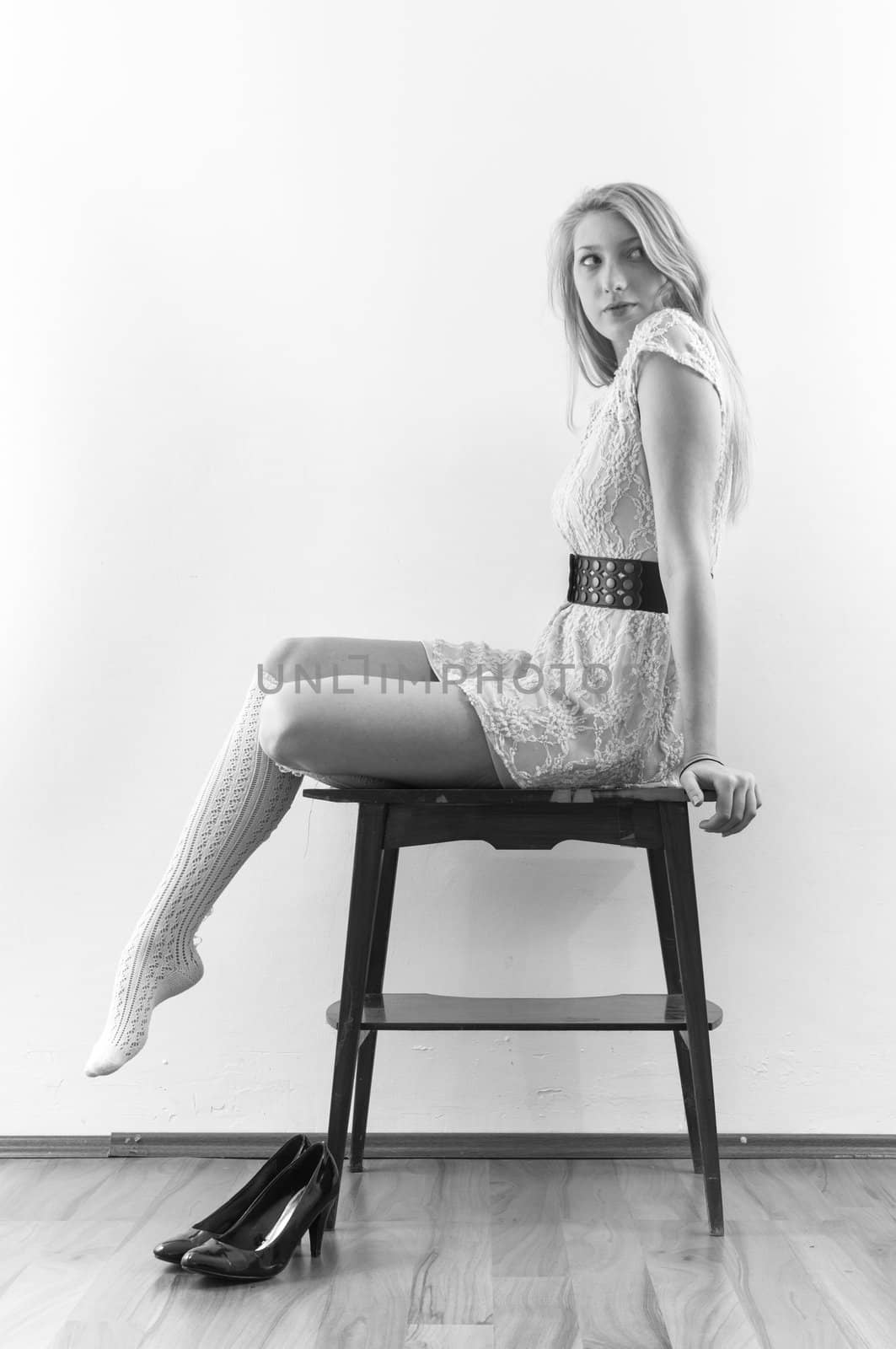 Beautiful model sitting on table against white background