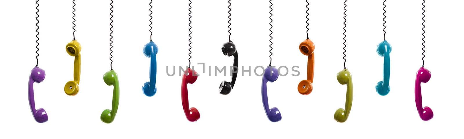 Multi colored handset pieces suspended by the phone cord, isolated on white background