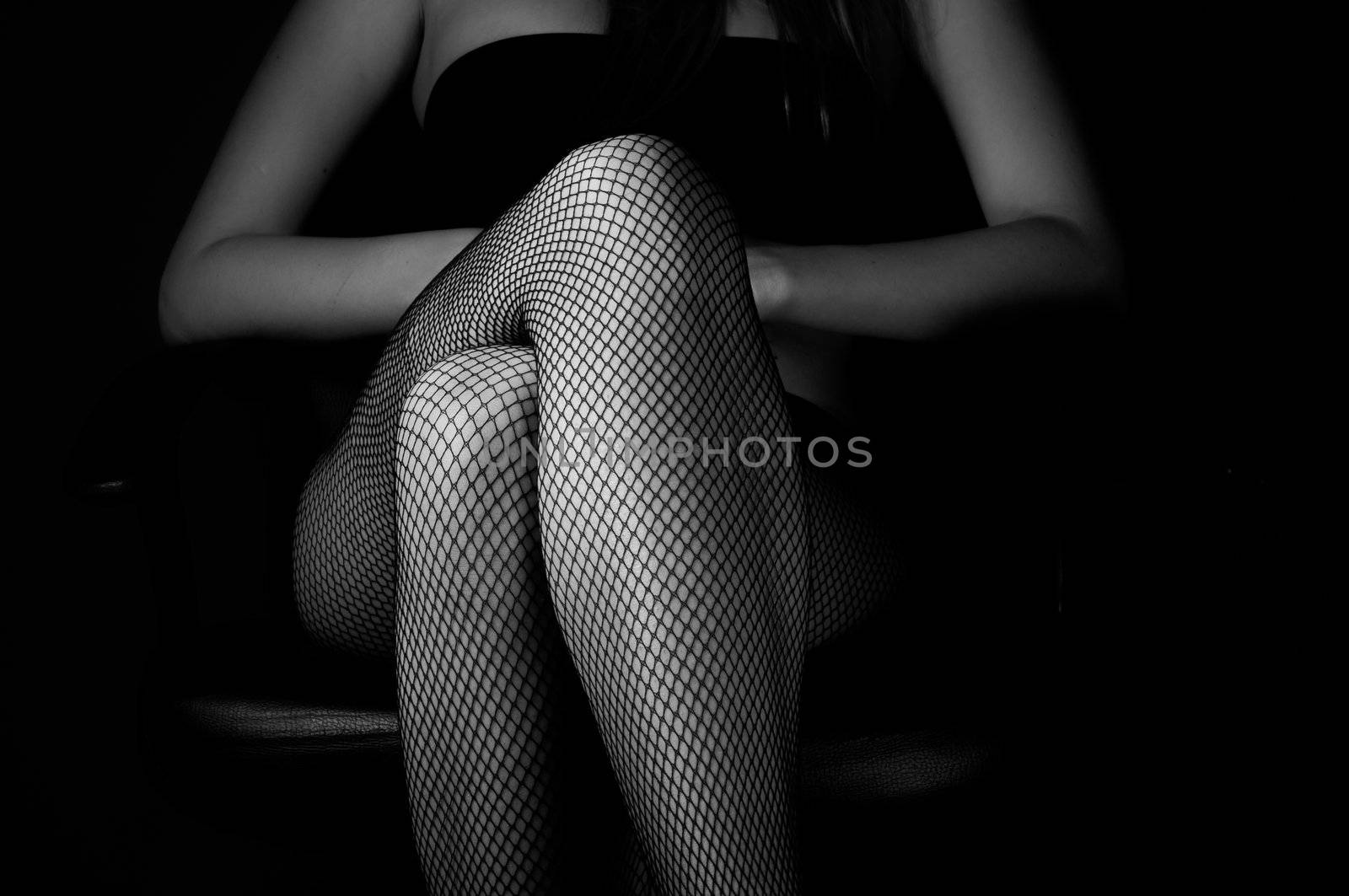 Girl in stockings  against dark background