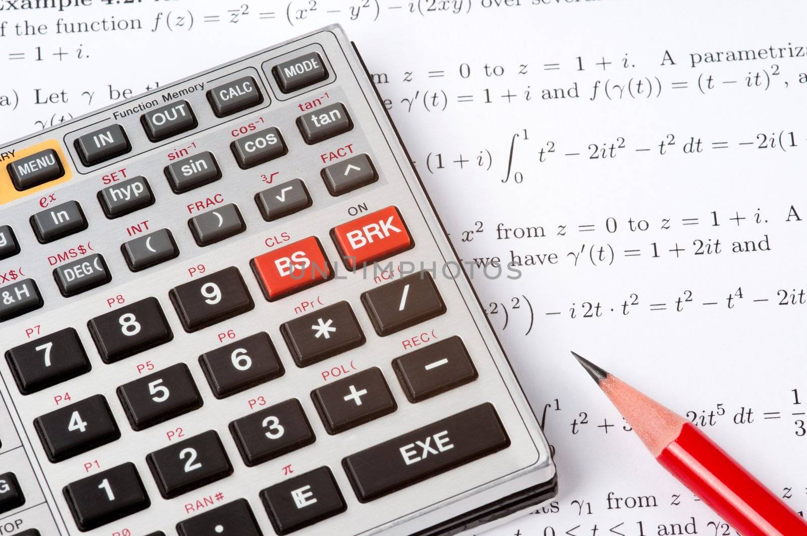 Scientific calculator and a red pencil on top of a sheet of paper with maths formulas