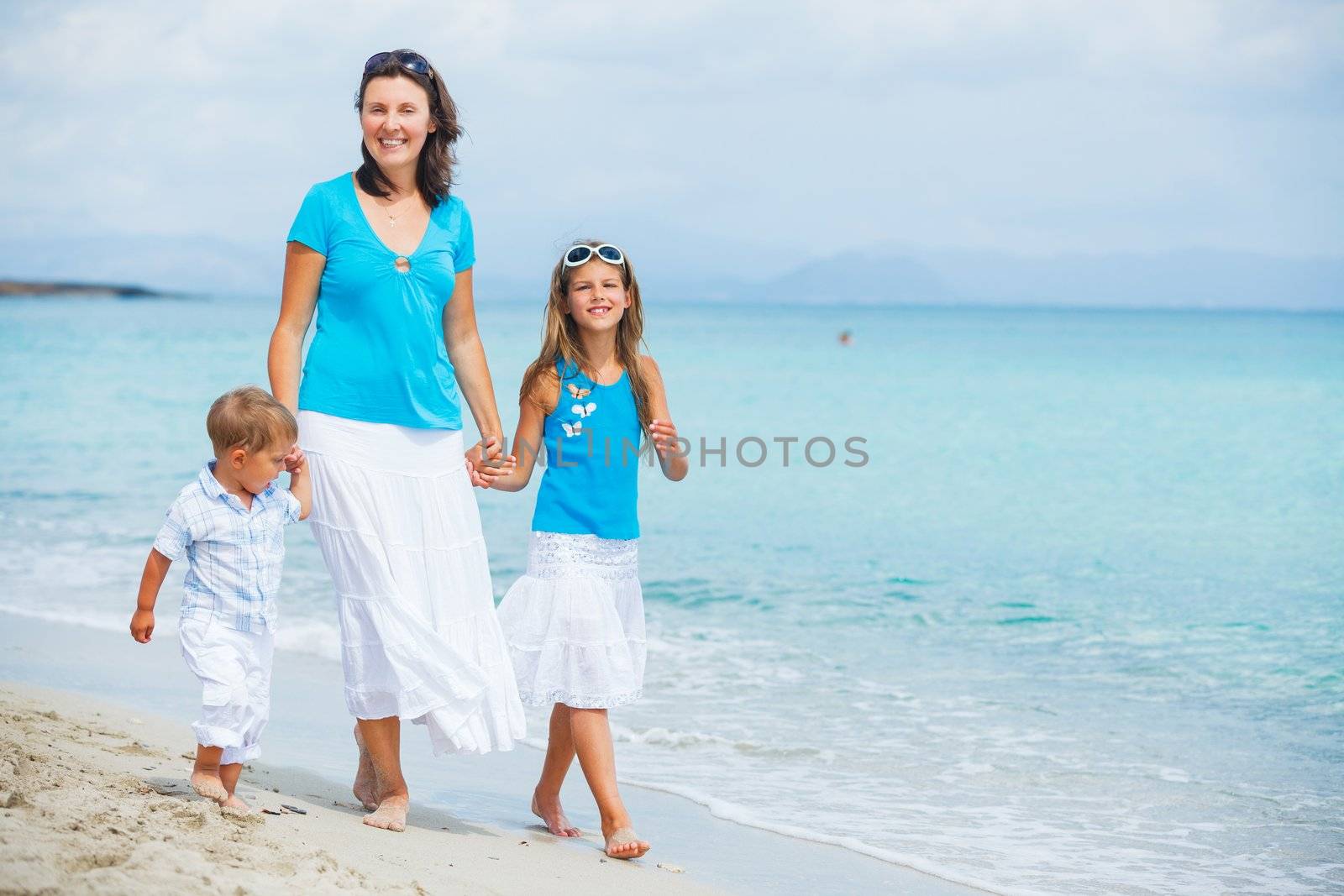 Mother and two kids having fun on beach by maxoliki