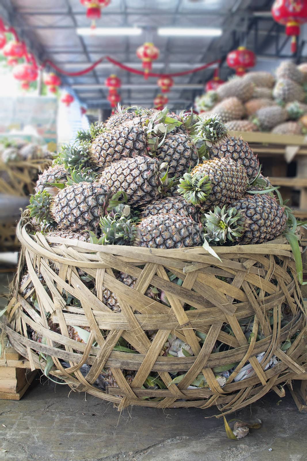 Pile of Pineapples in Big Woven Basket in Southeast Asian Fruits and Vegetables Market