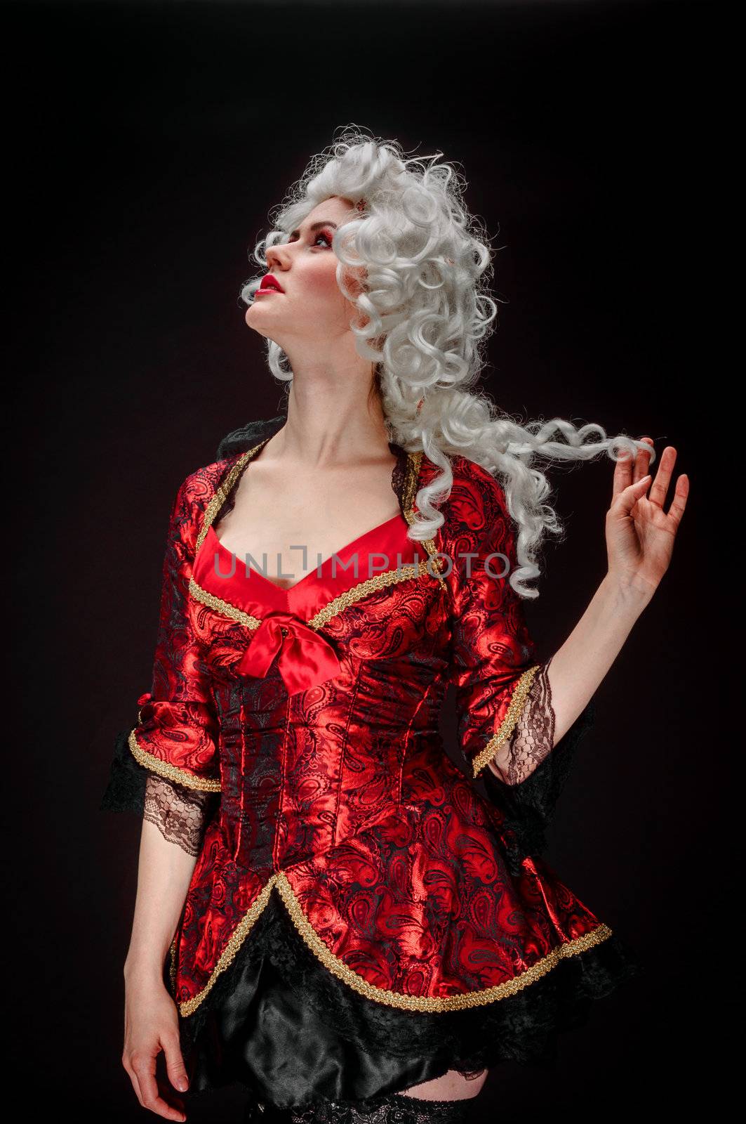 Young woman in baroque costume against dark background