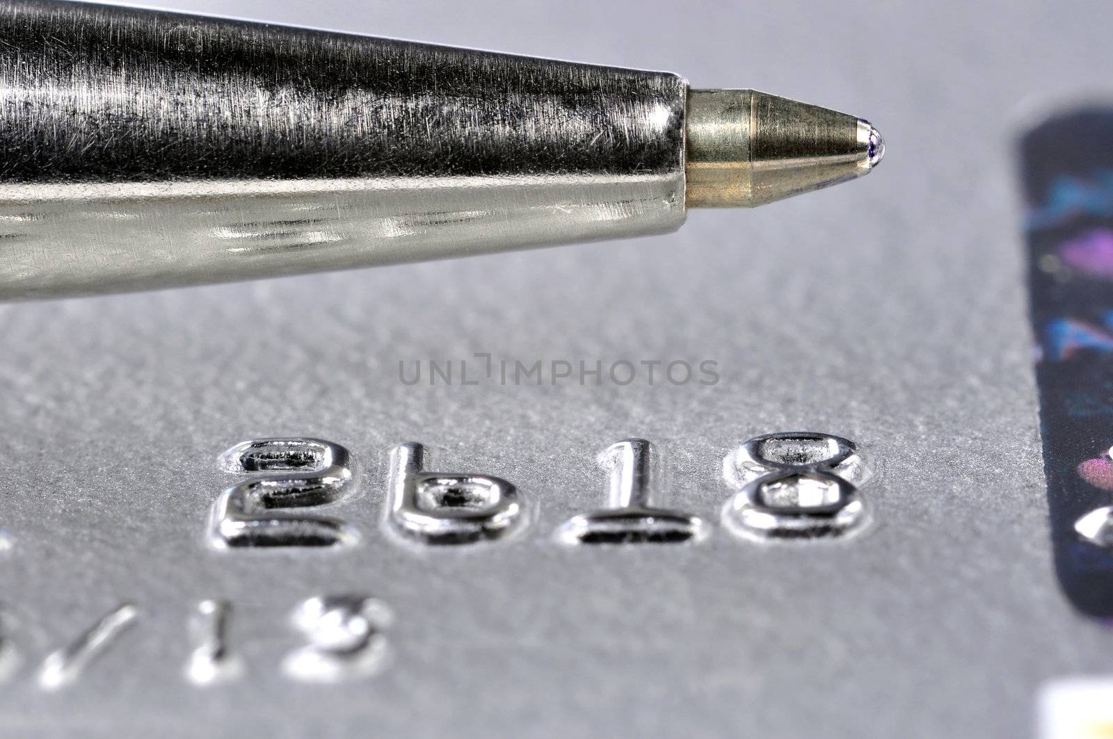 Closeup of a credit card with a silver pen on top of it