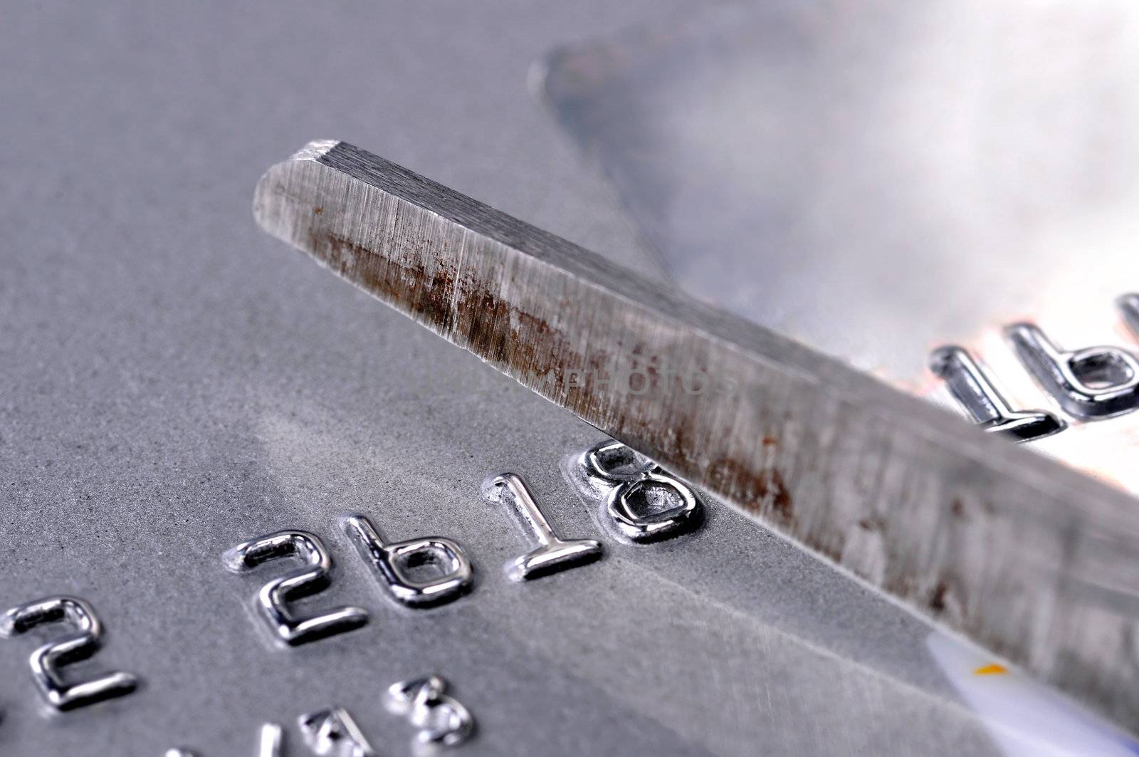 Scissors cutting up a silver credit card