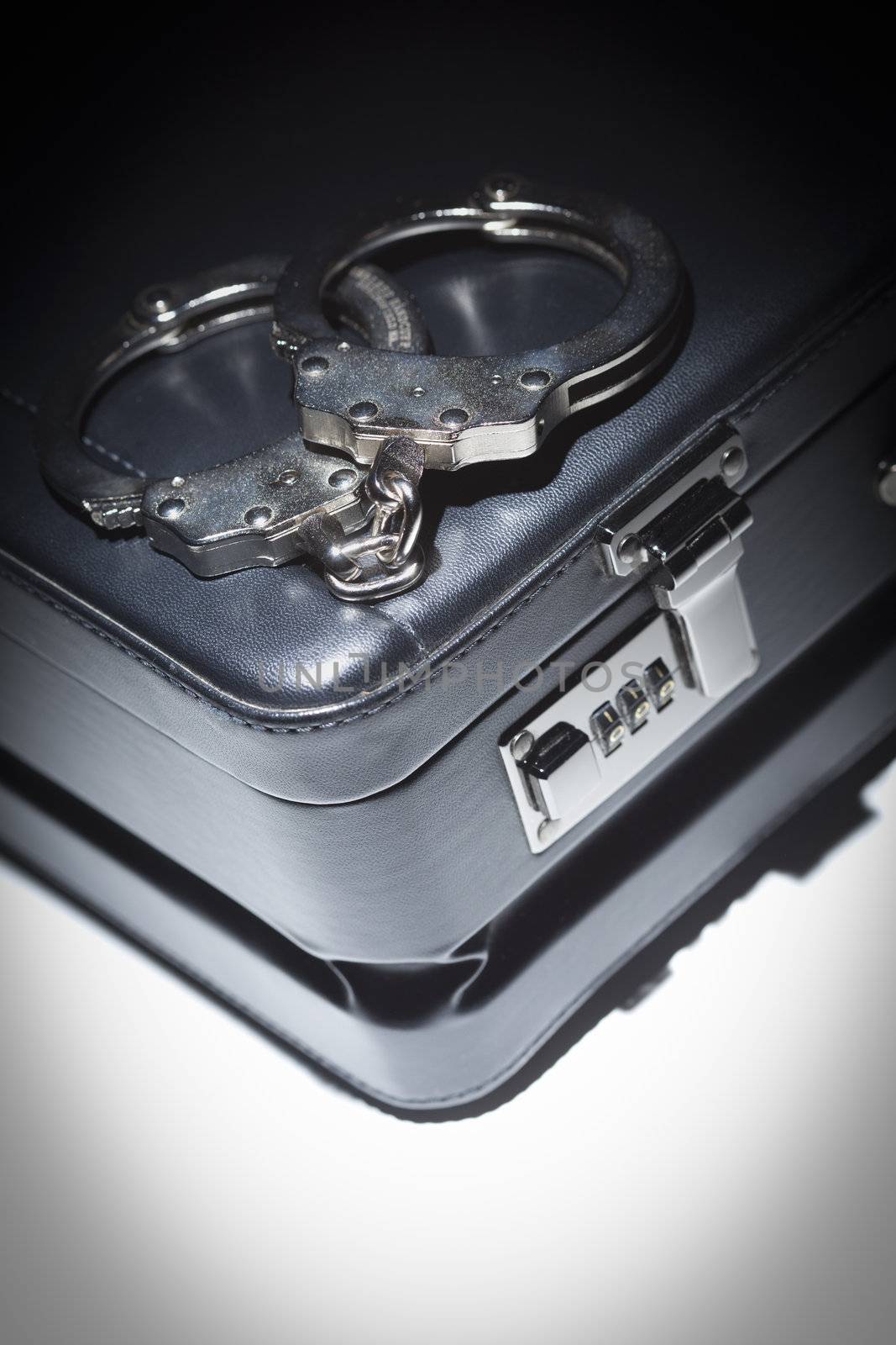 Pair of Handcuffs and Briefcase Under Spot Light by Feverpitched