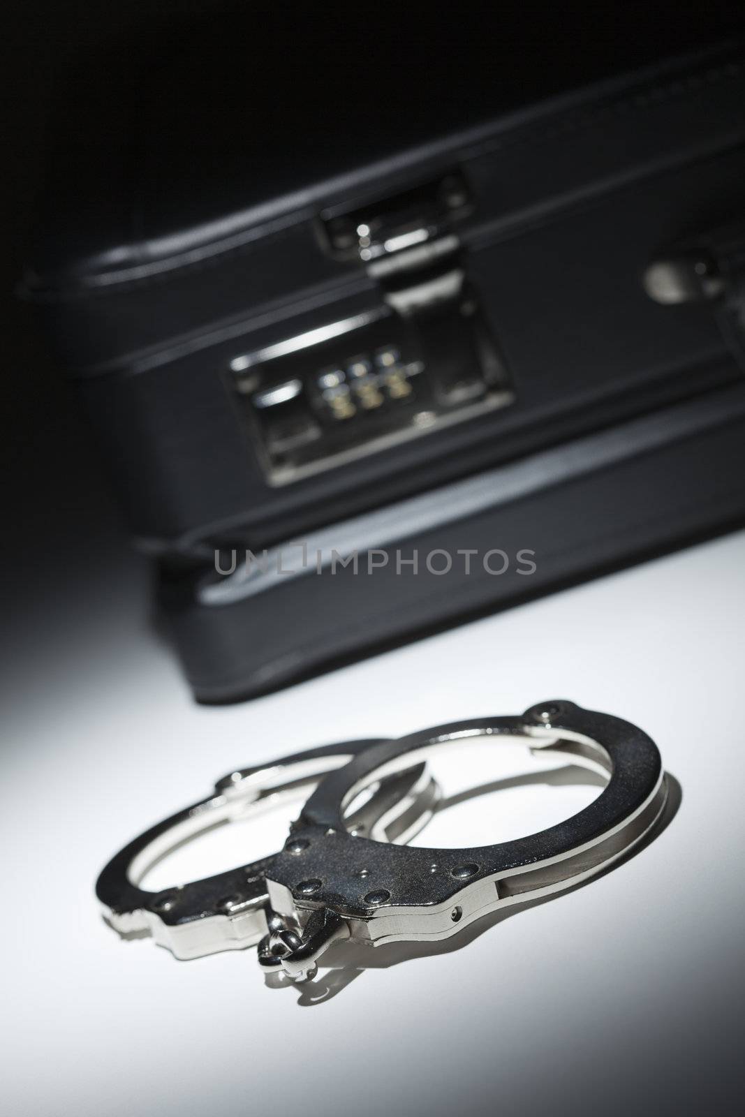 Pair of Handcuffs and Briefcase Under Spot Light Abstract.