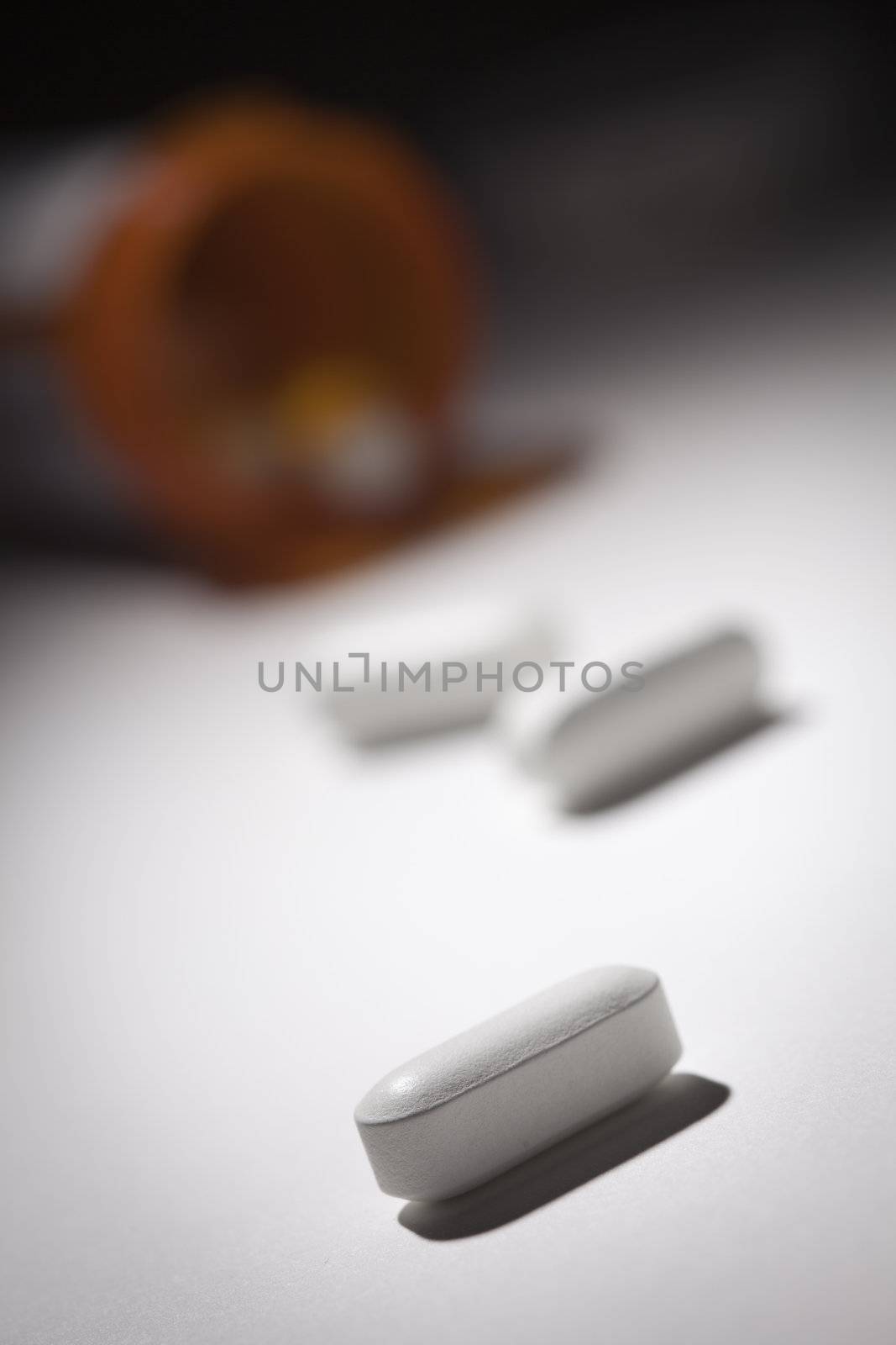 Medicine Bottle and Pills Under Spot Light by Feverpitched