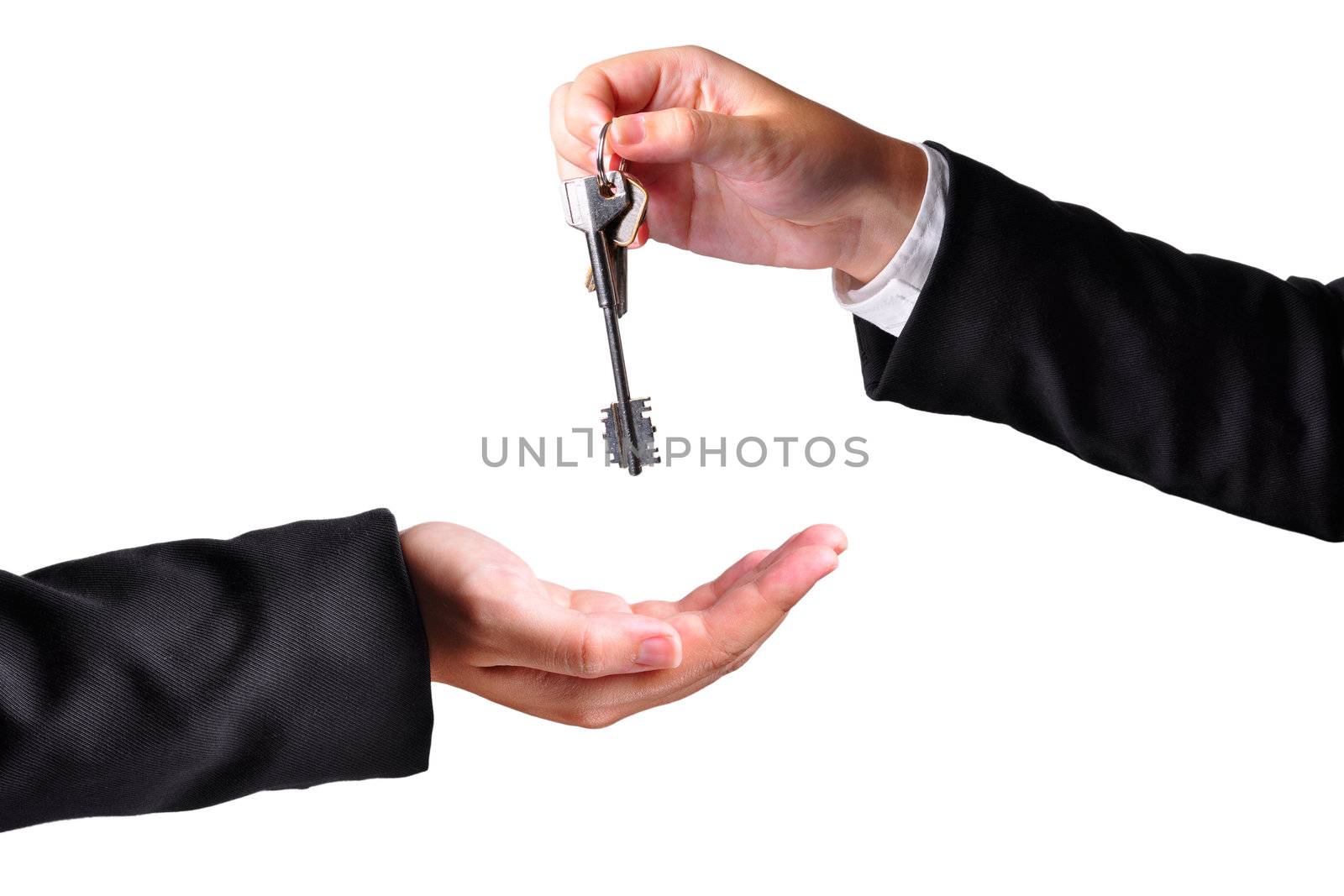 A hand giving a key to another hand. Both persons in suits. Isolated.