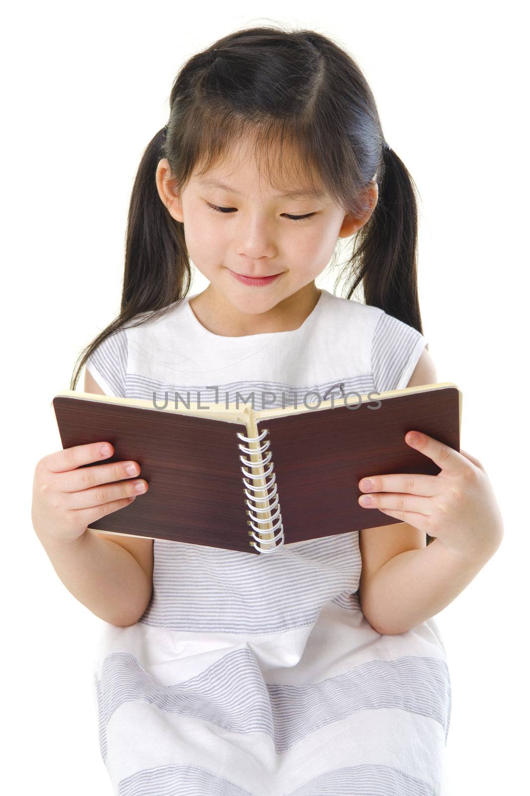 Little Asian girl reading on white background