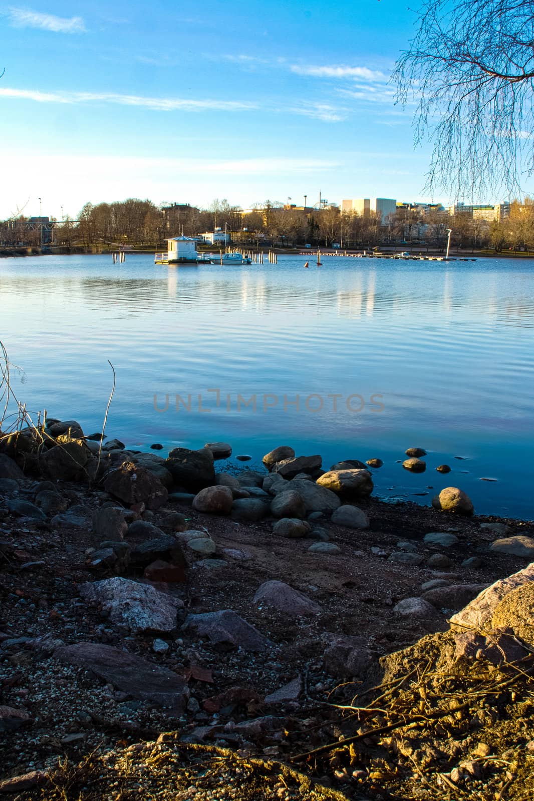 Cityscape shot of a spring lake and warm evening sunshine.