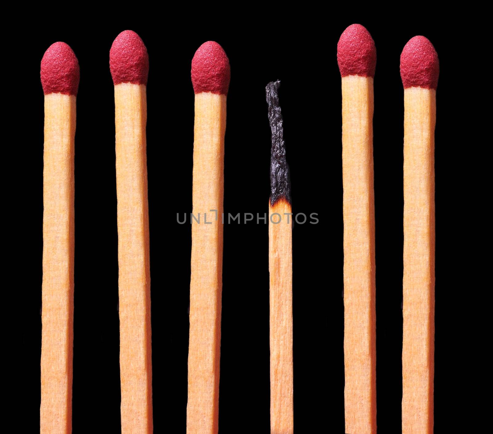 Group of matches with a burned one in the middle