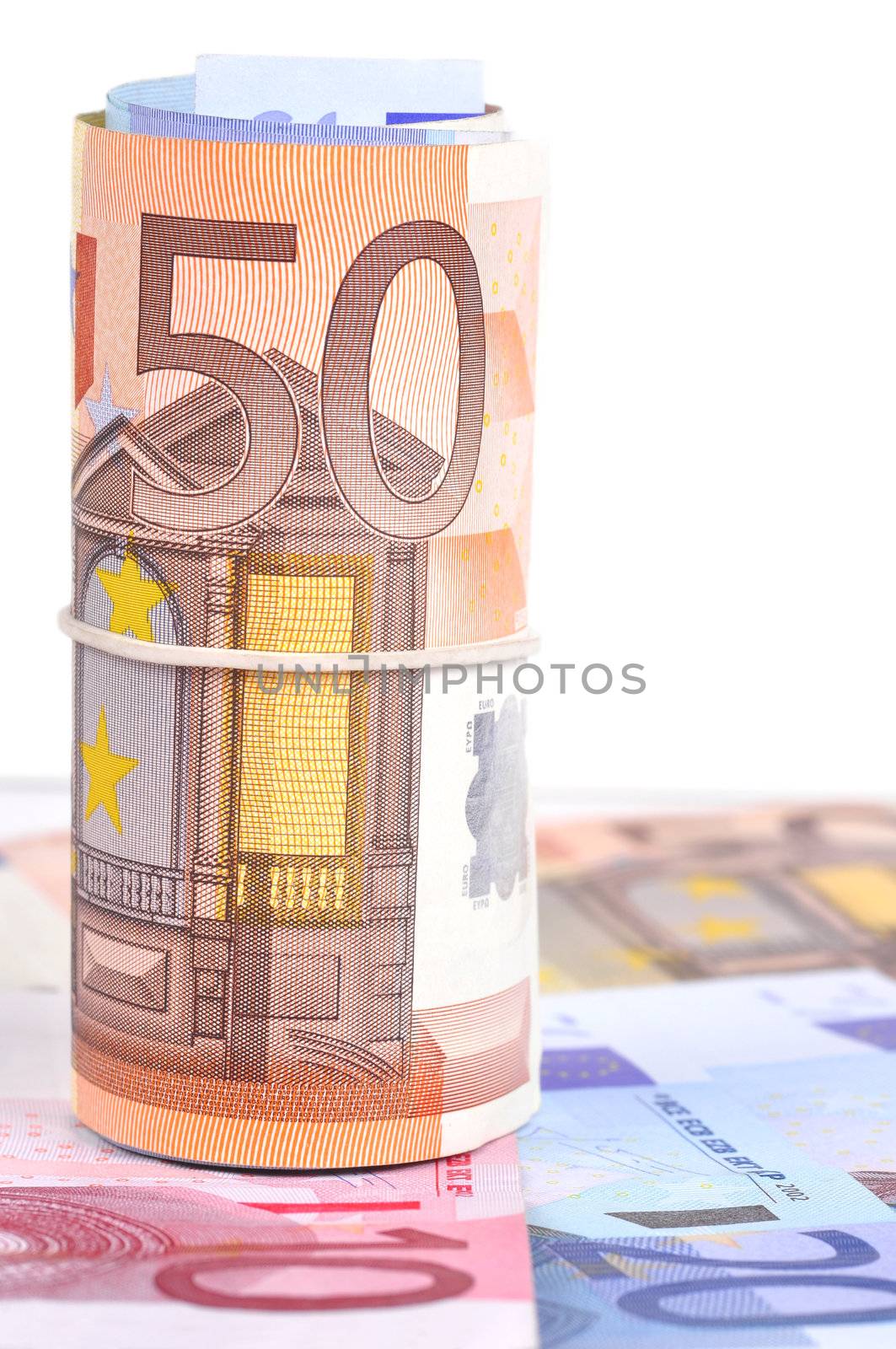 Roll of euro bank notes on top of some more notes