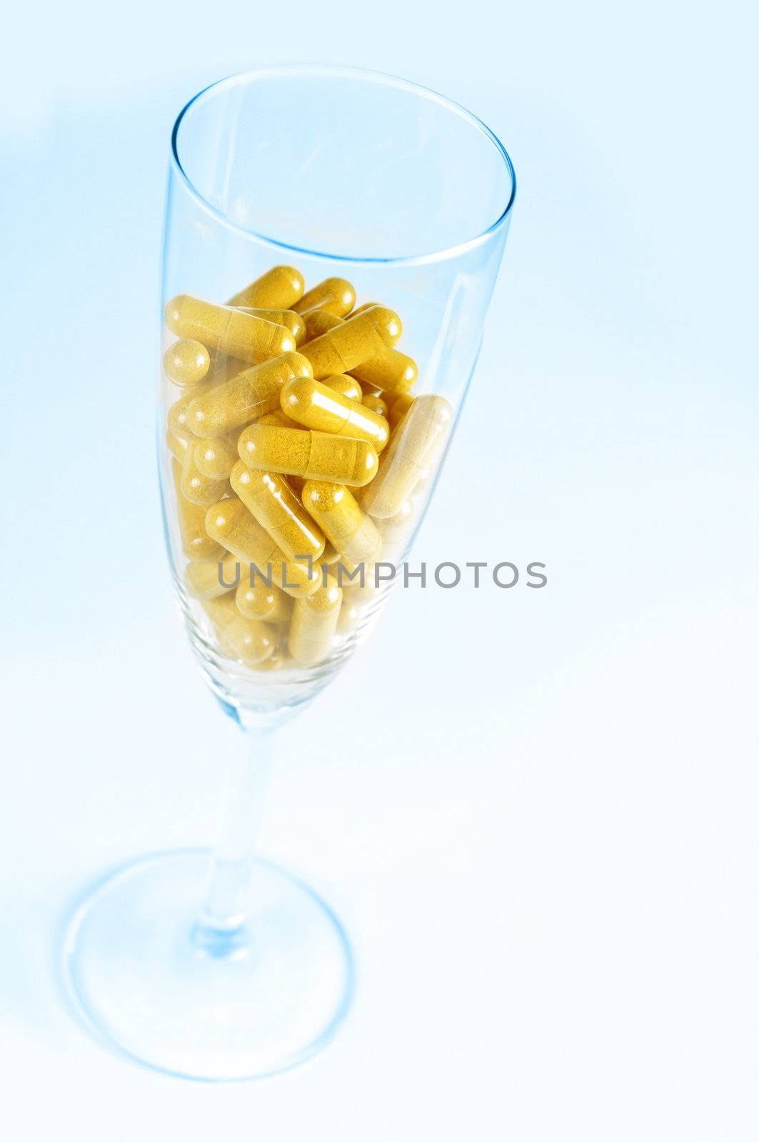 Conceptual image about the risk of taking pills with alcohol. Blue background.